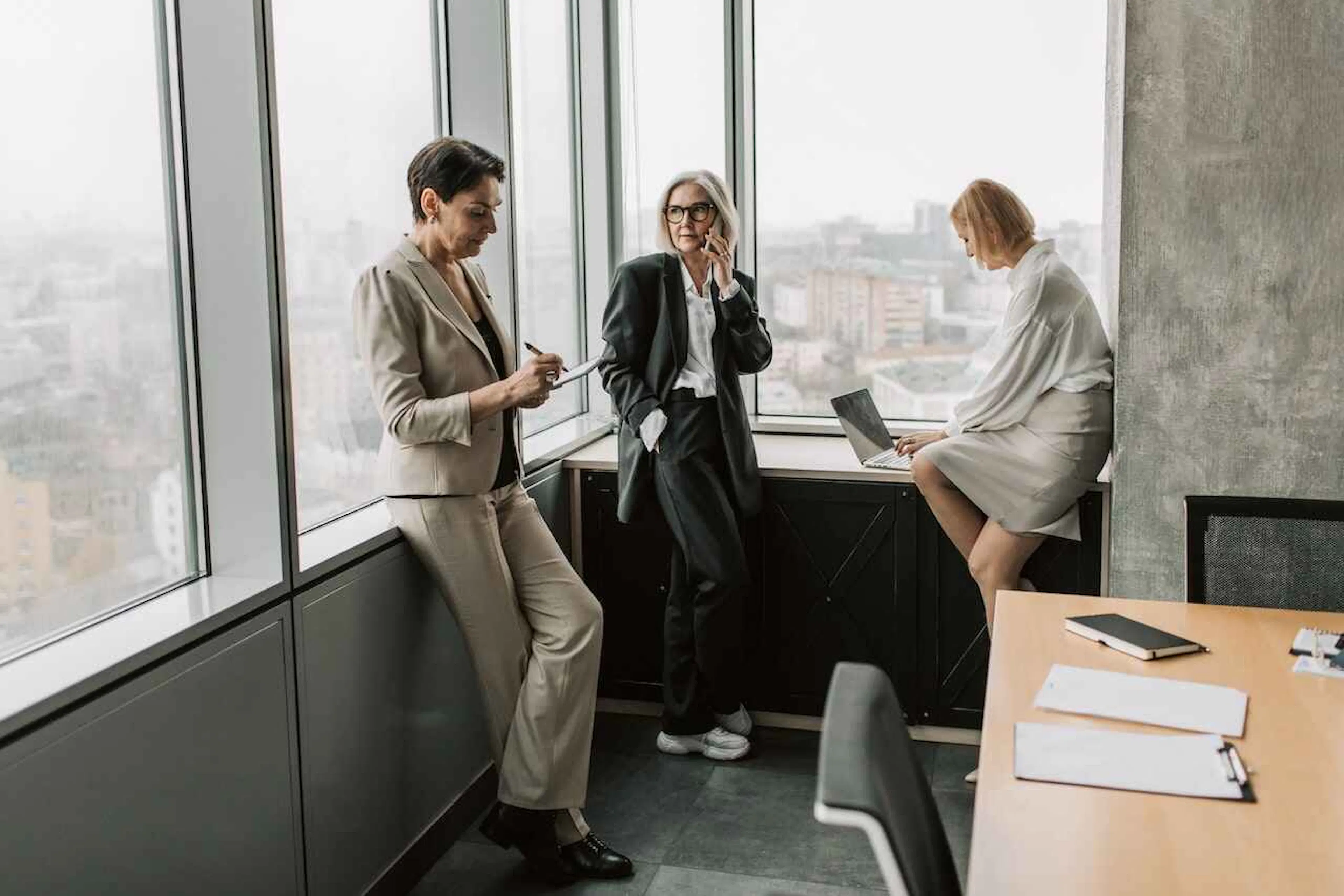 Three businesswomen working in an office with windows