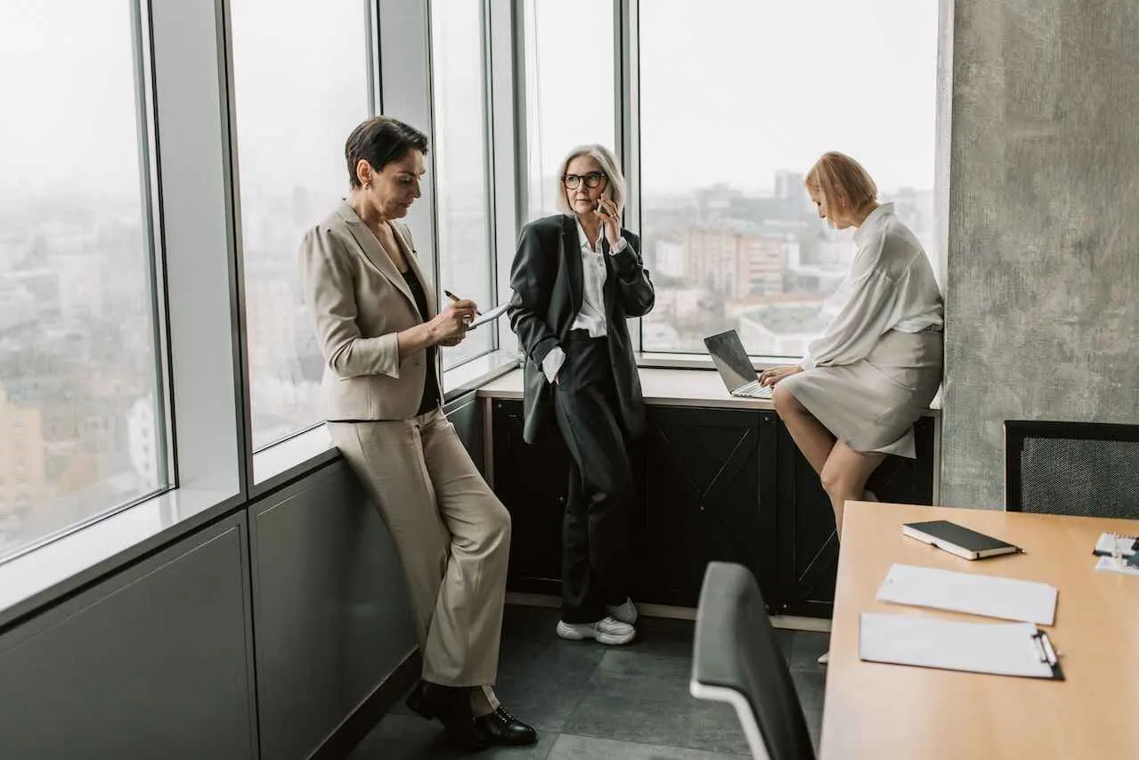 Three businesswomen working in an office with windows