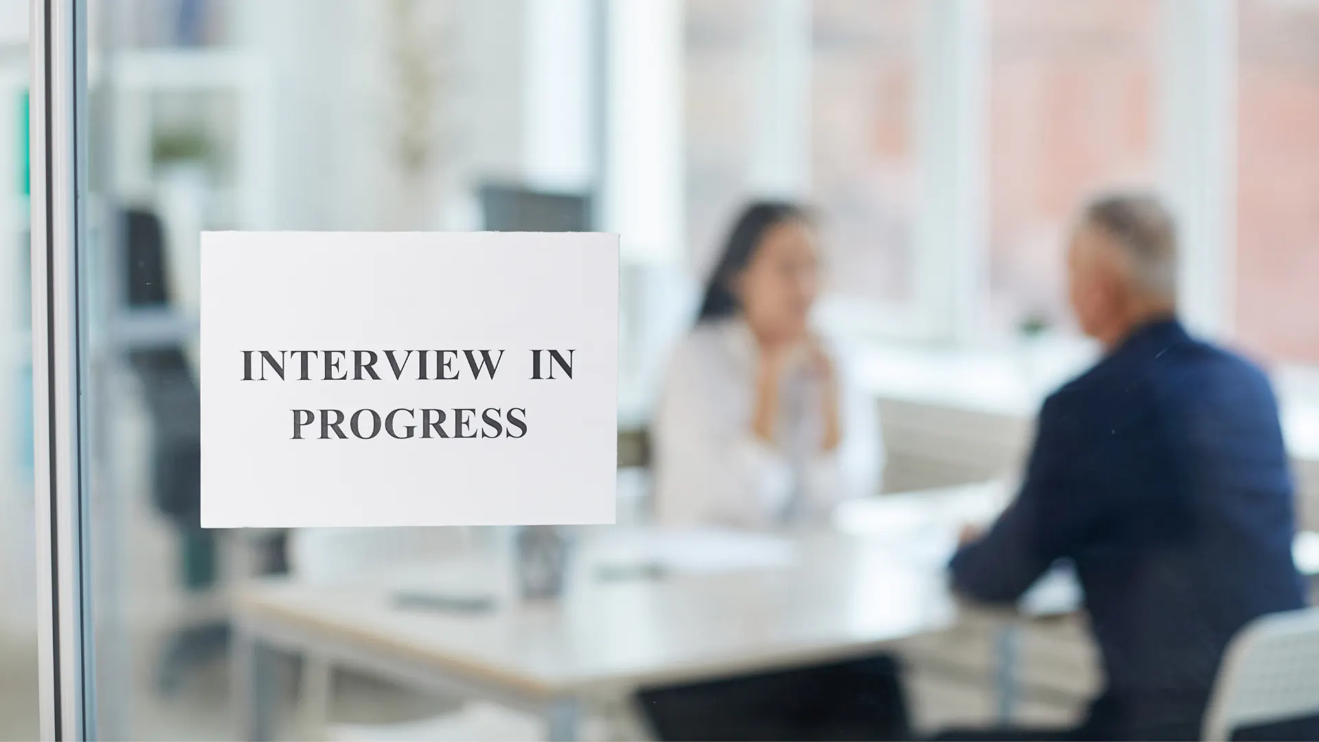 Sign outside meeting room stating interview in progress