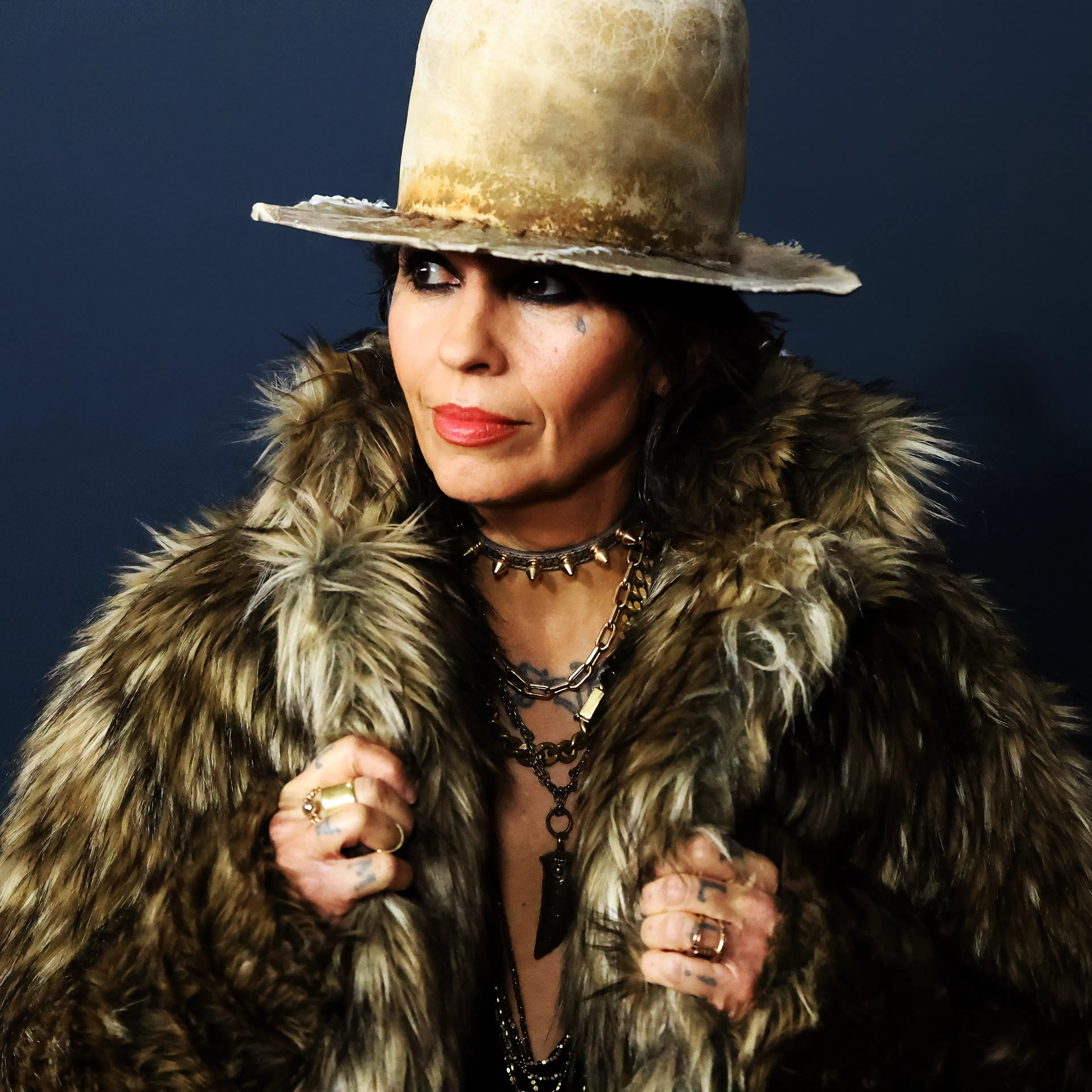 Close up of Linda Perry wearing trademark oversized hat
