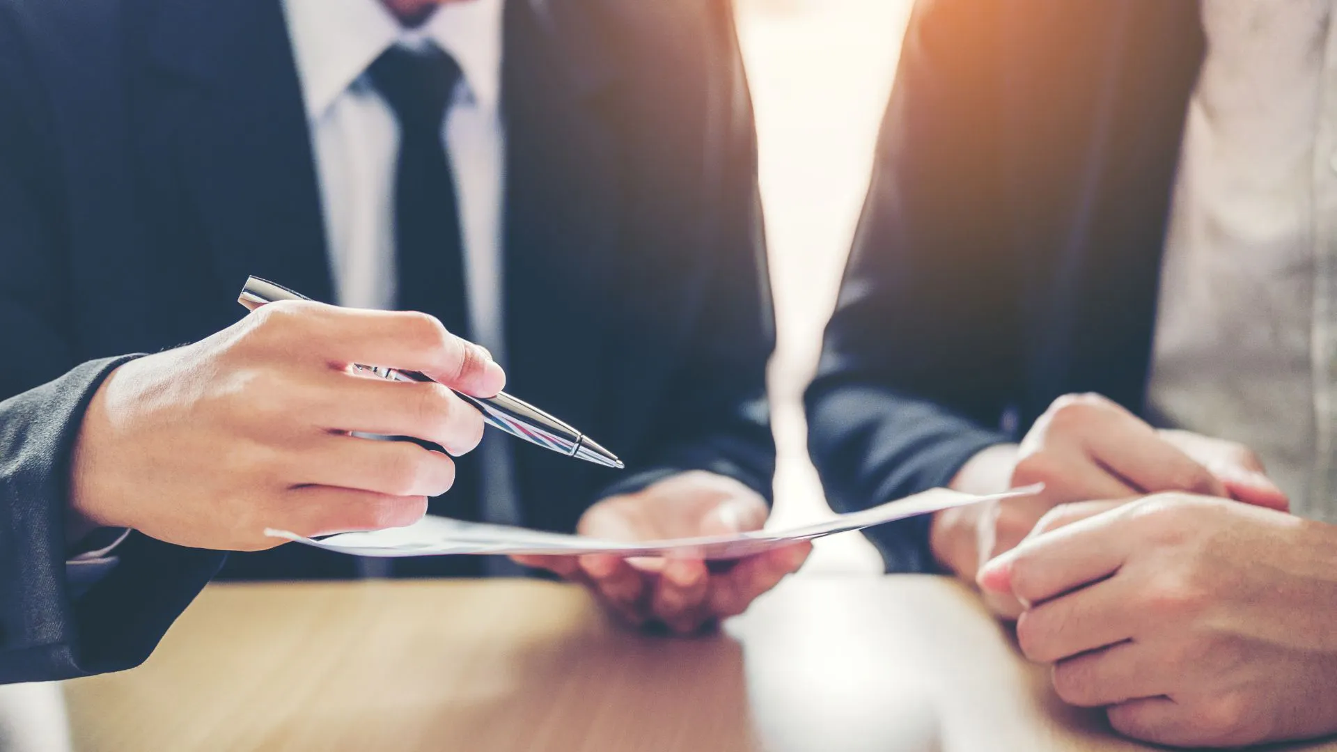Close up on two sets of hands, one holding paperwork