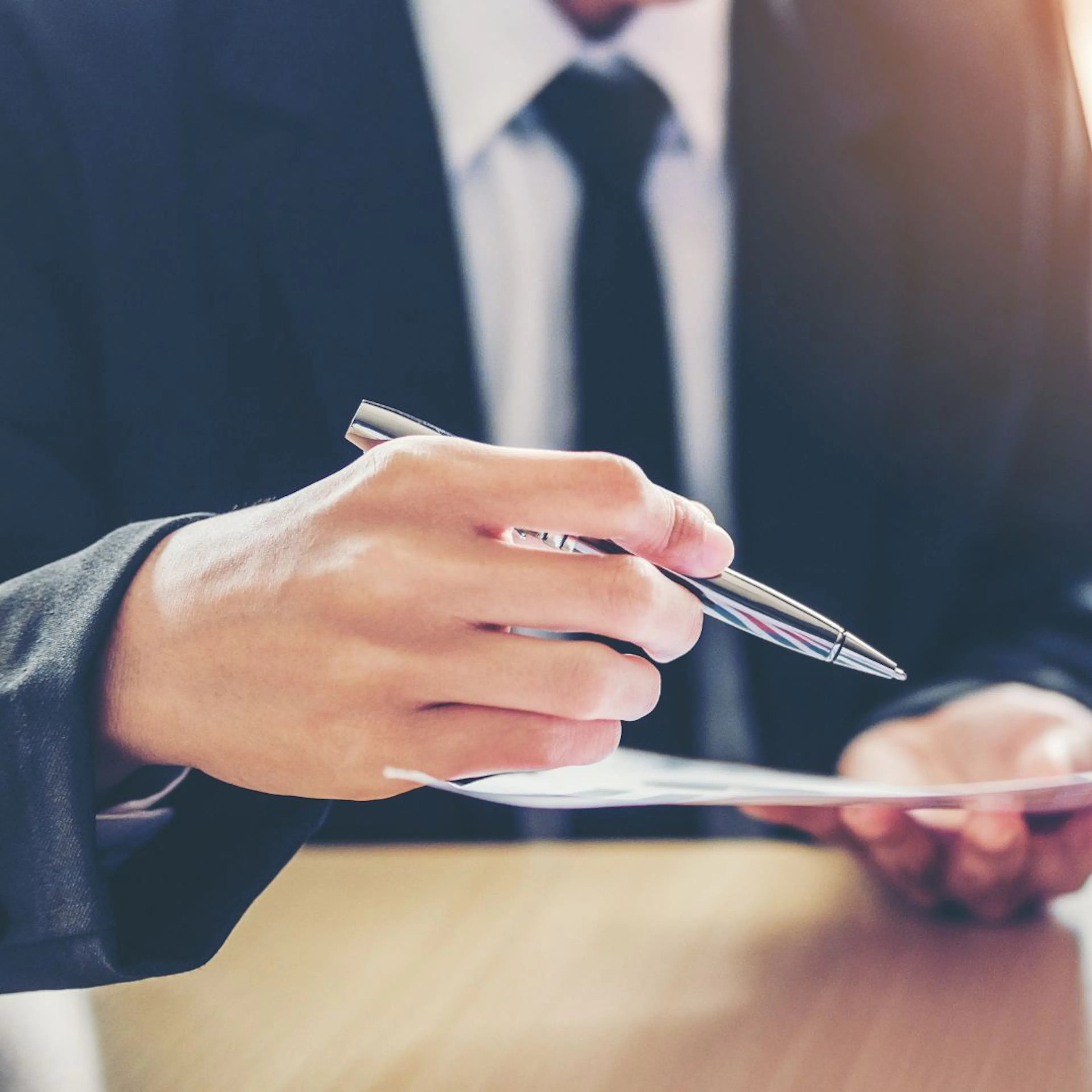 Close up on two sets of hands, one holding paperwork