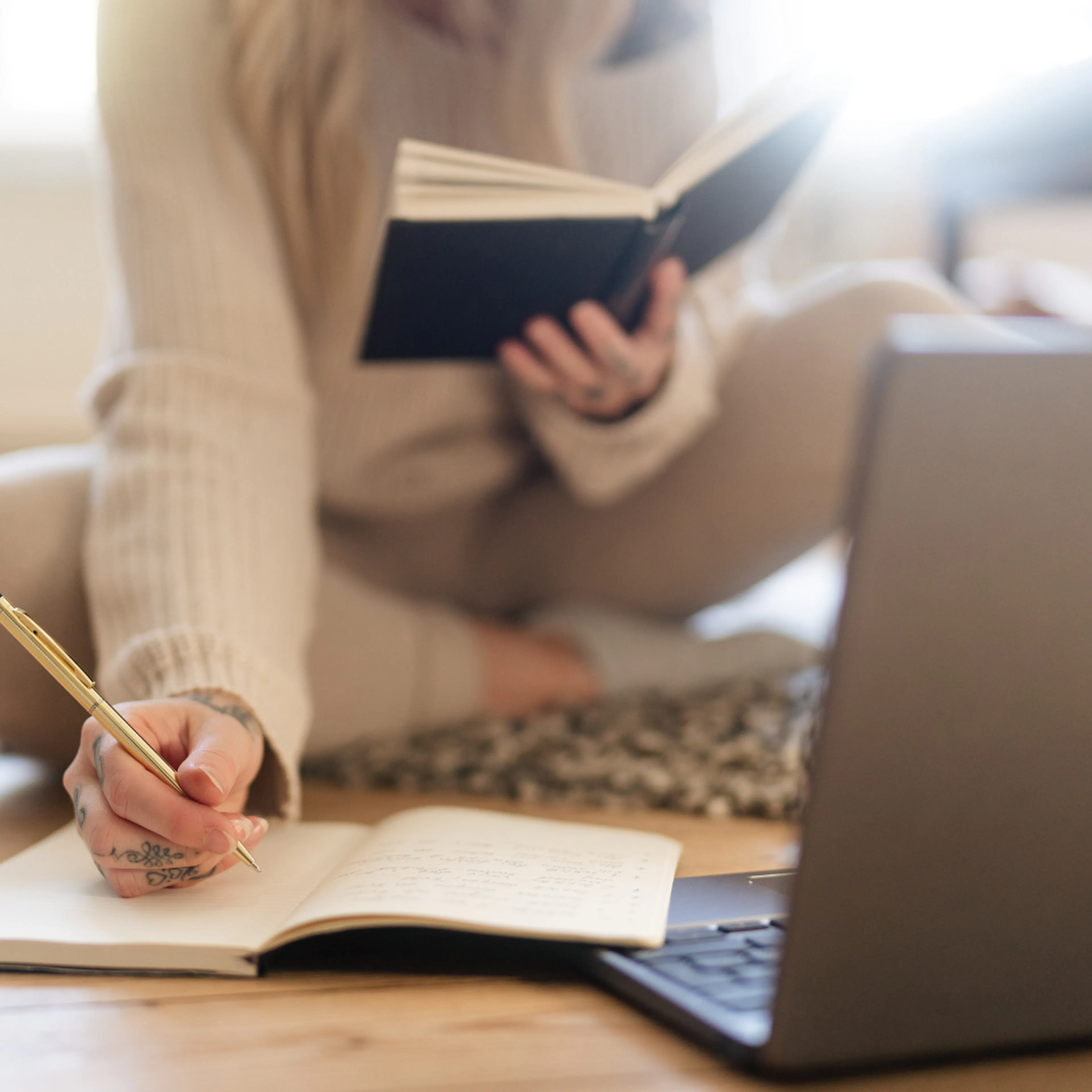woman sat on floor with books and laptop