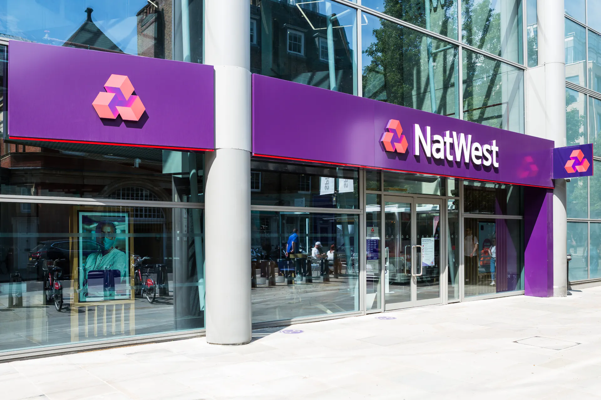 Outside a branch of NatWest in the sunshine.