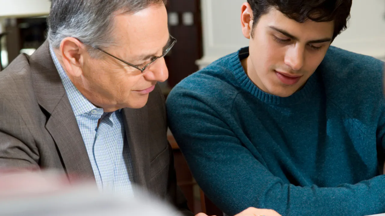 Two employees chatting, one older one younger, illustrating reverse mentoring