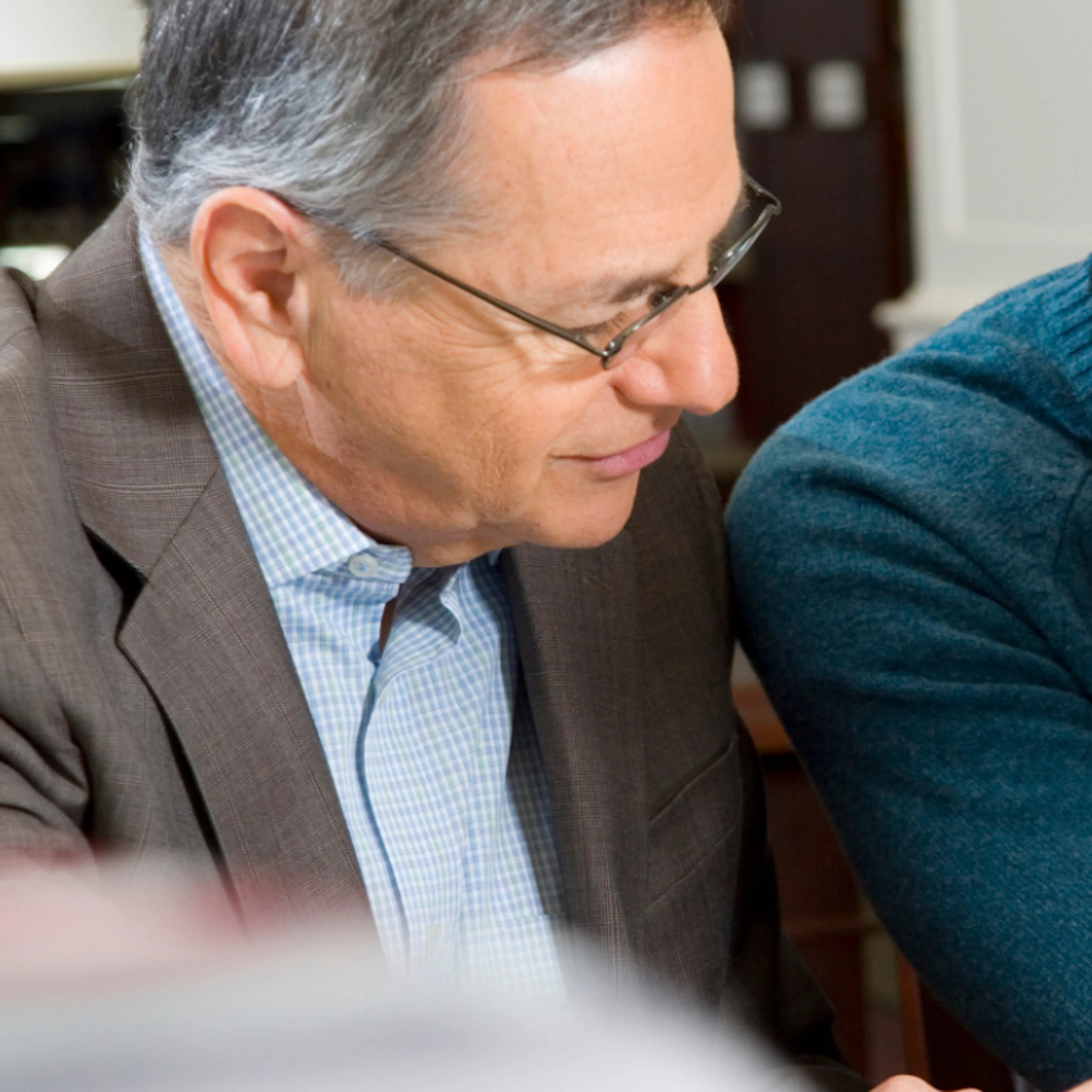 Two employees chatting, one older one younger, illustrating reverse mentoring