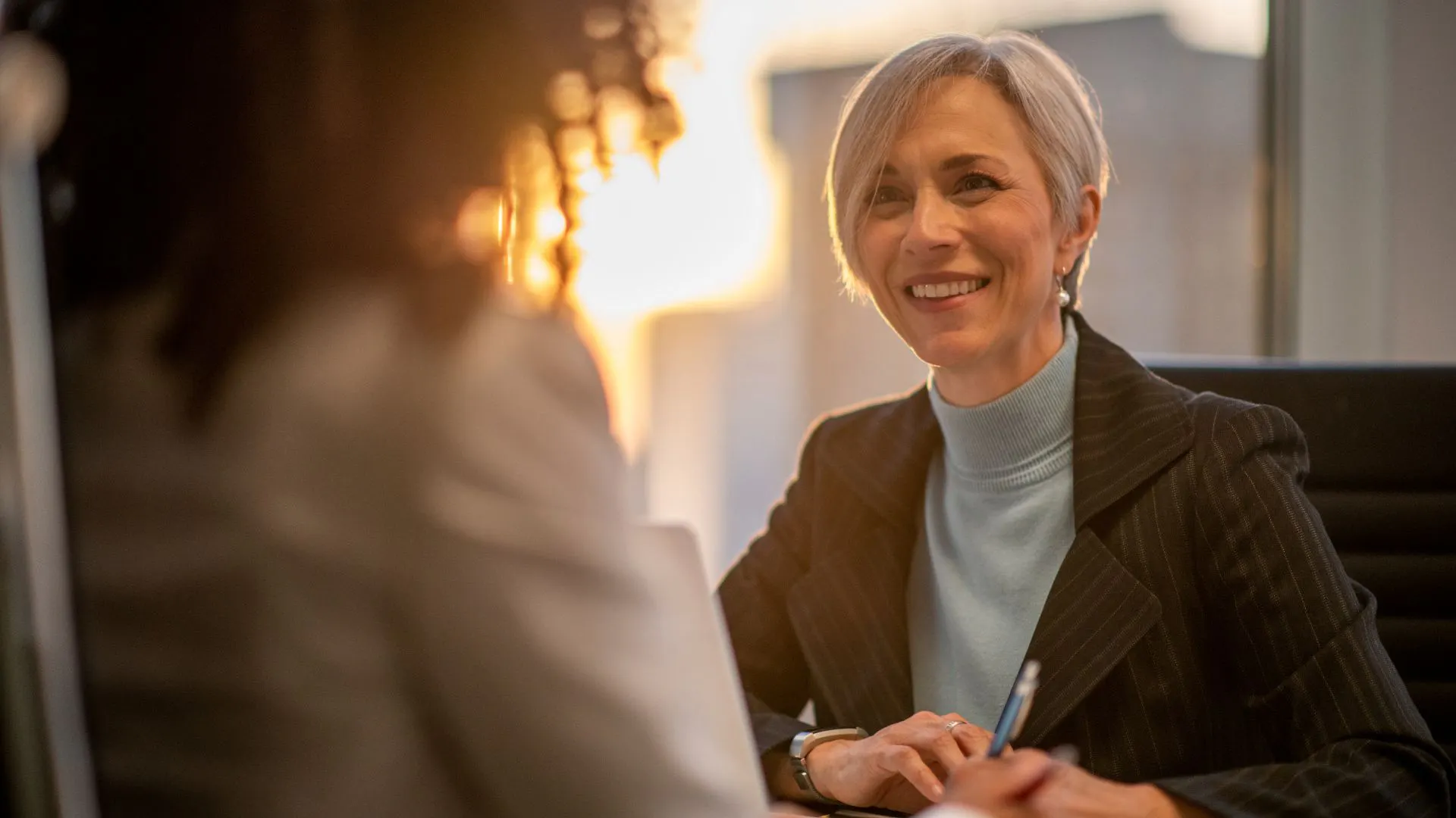 confident older female talking to person with back to camera