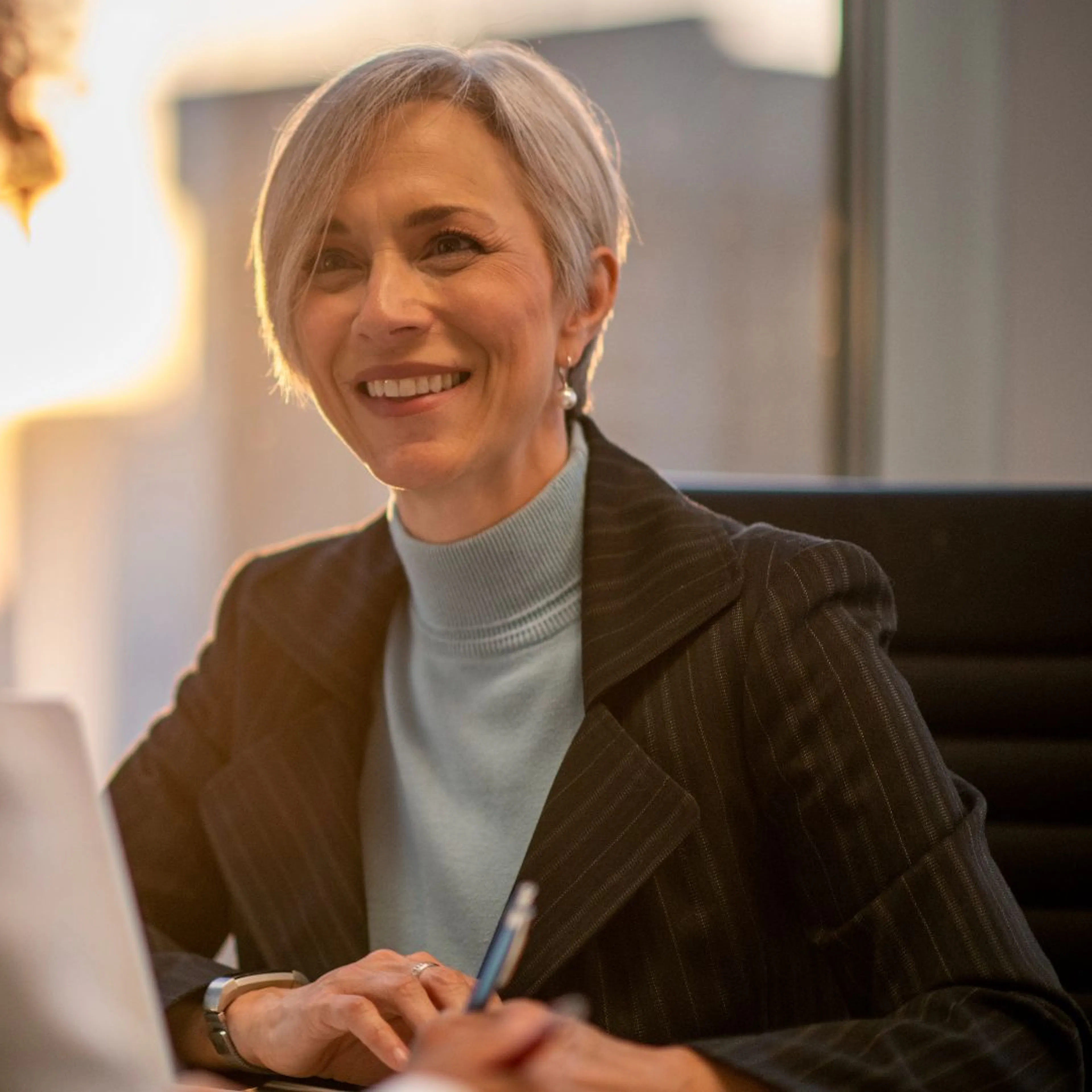confident older female talking to person with back to camera