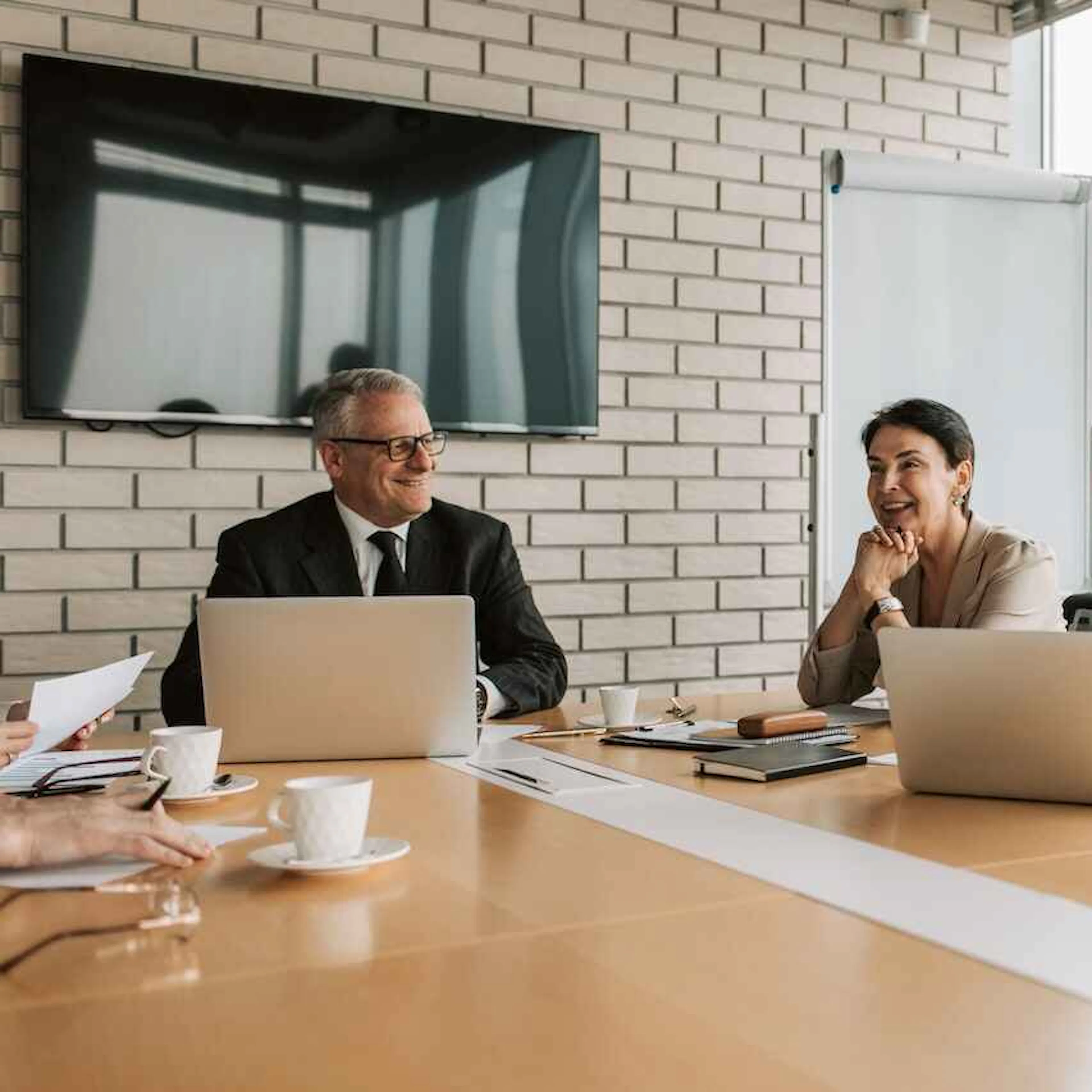 One man and two women sitting at a boardroom table