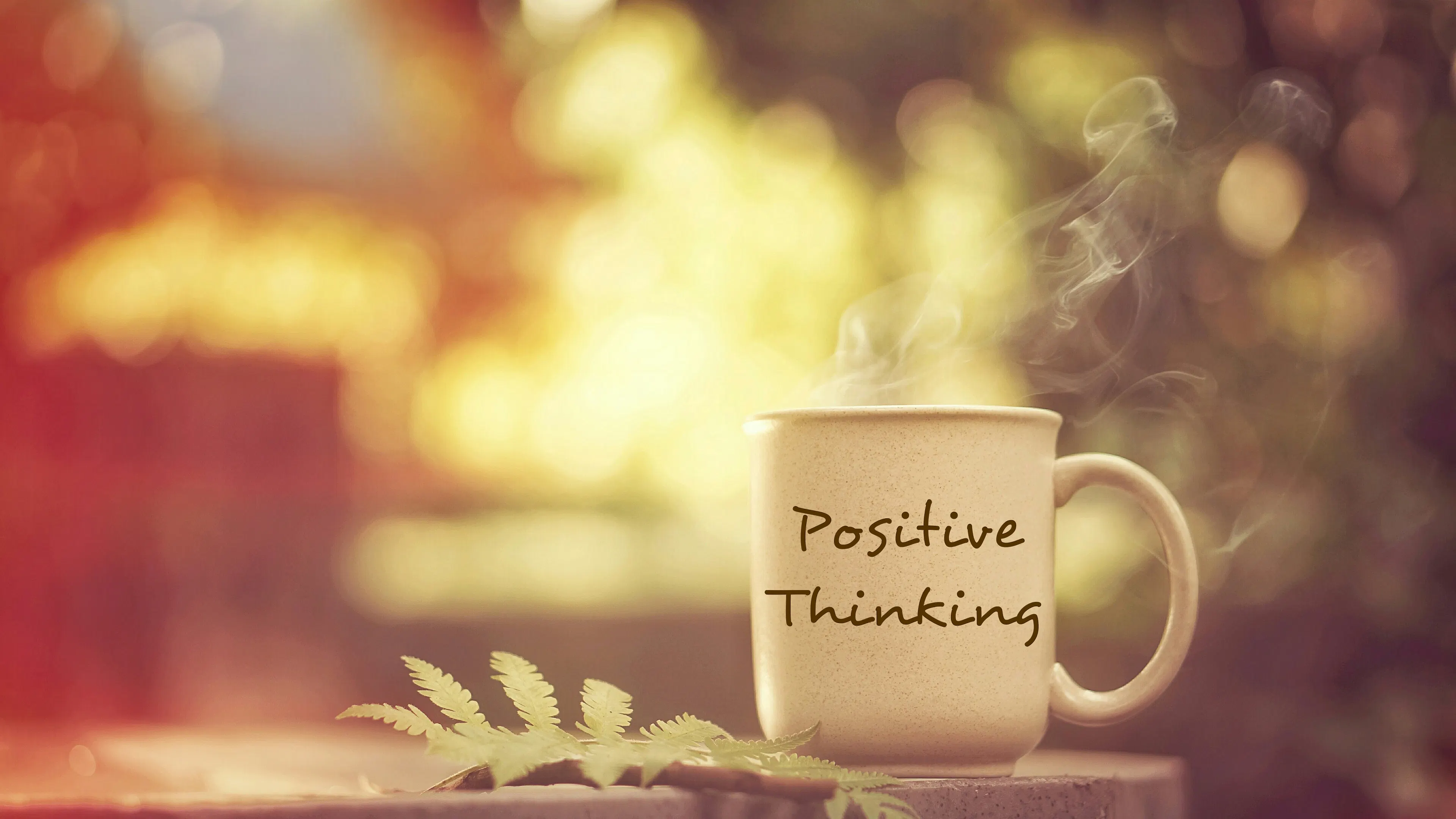 positive thinking mug on table with leaf
