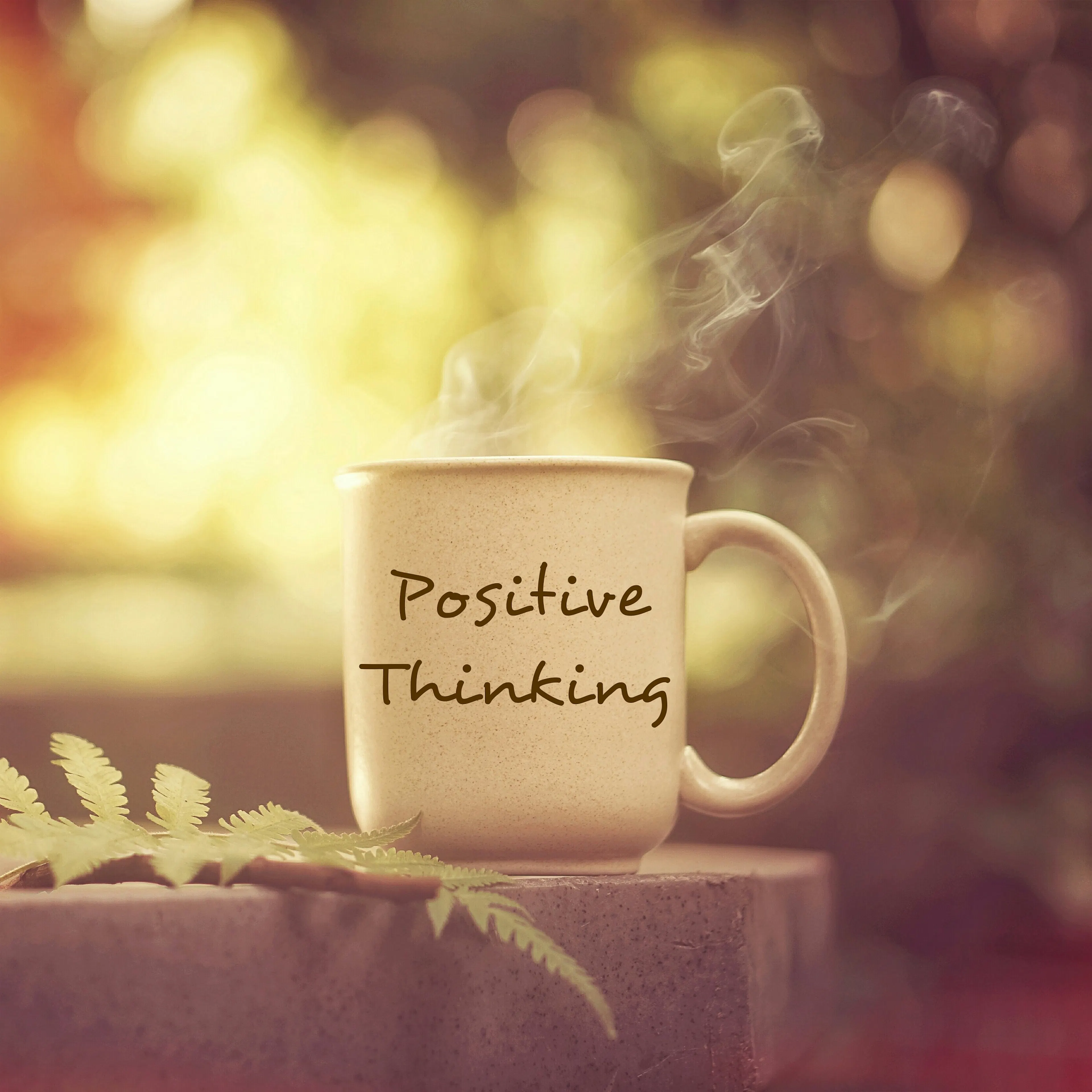 positive thinking mug on table with leaf