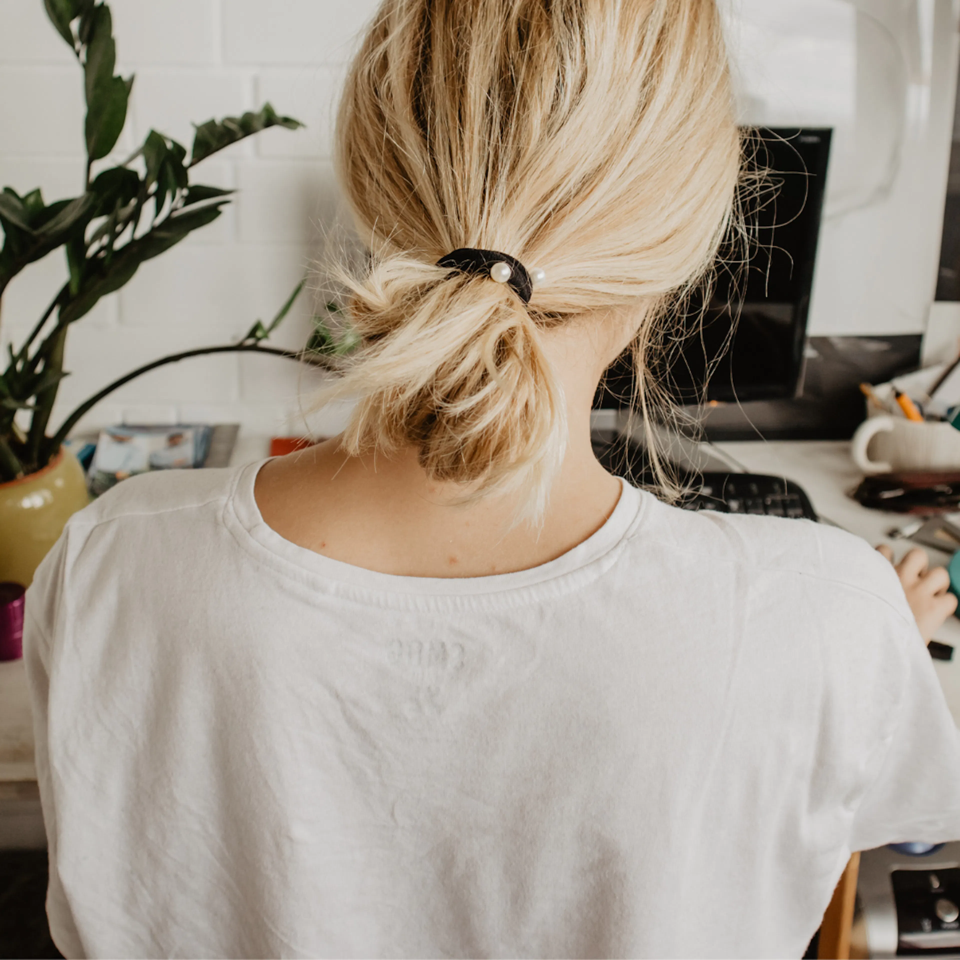 Back of female sat at a home desk
