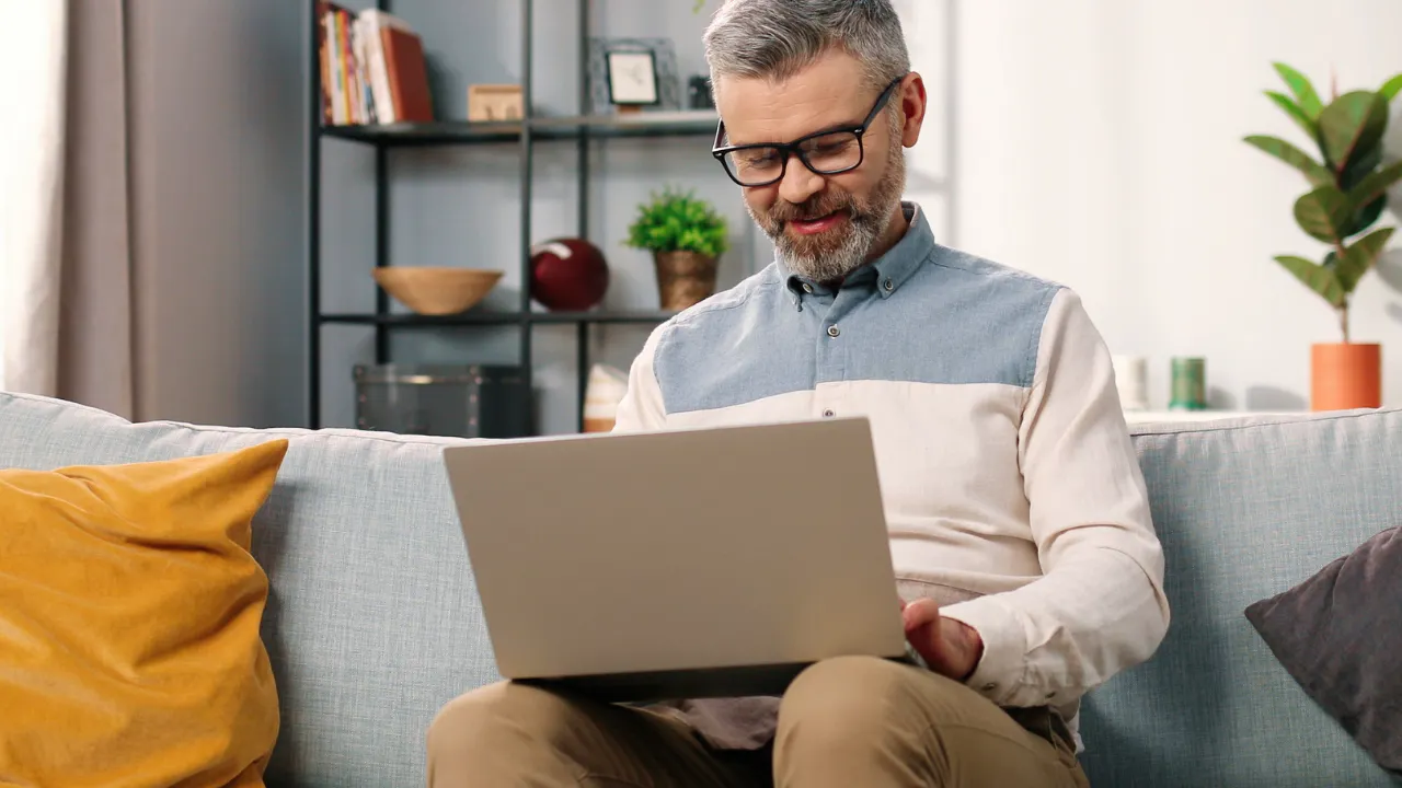 Man on laptop on sofa