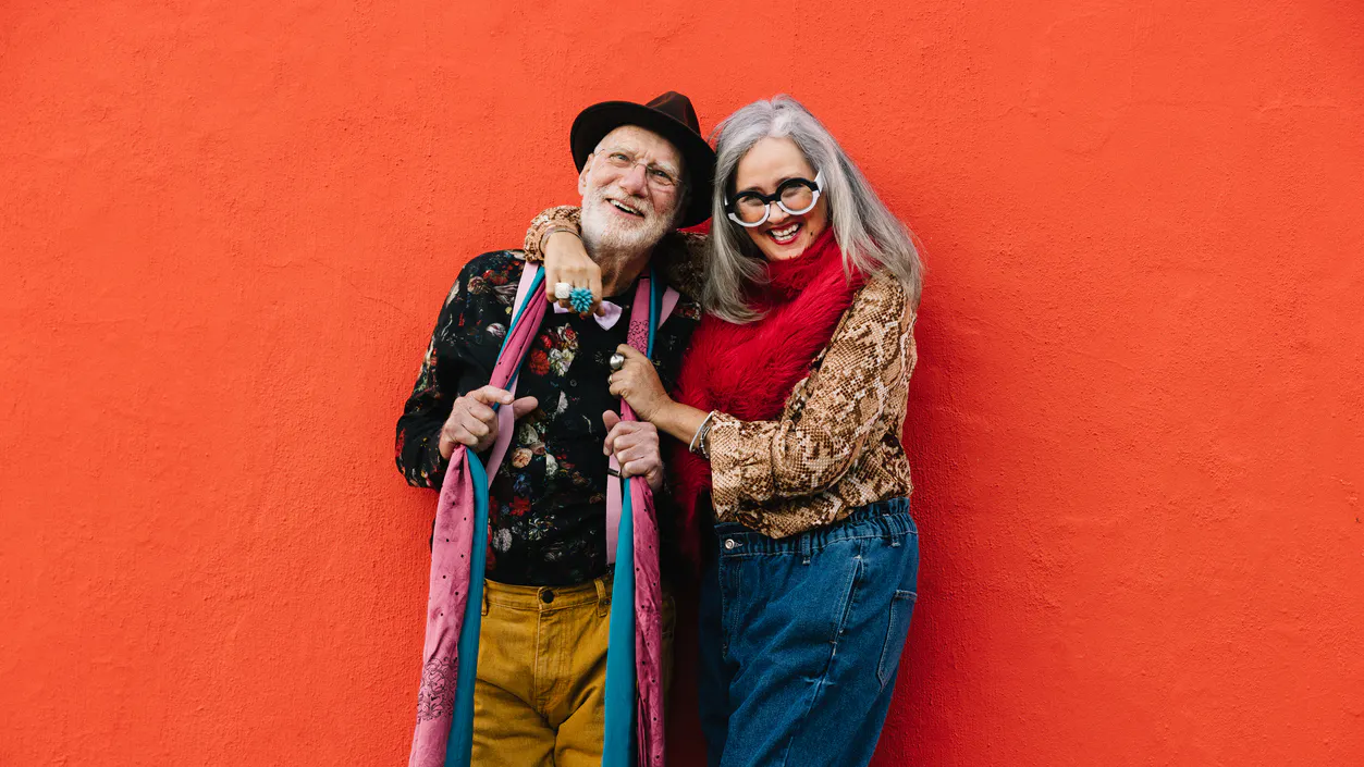 mature man with hat and woman in glasses smiling