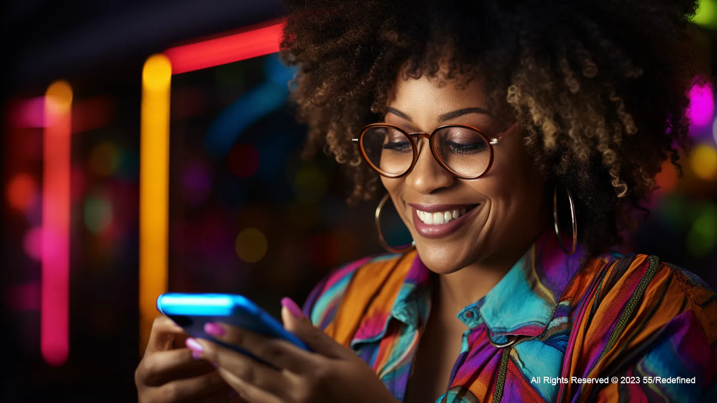 Black female wearing glasses smiling looking at phone
