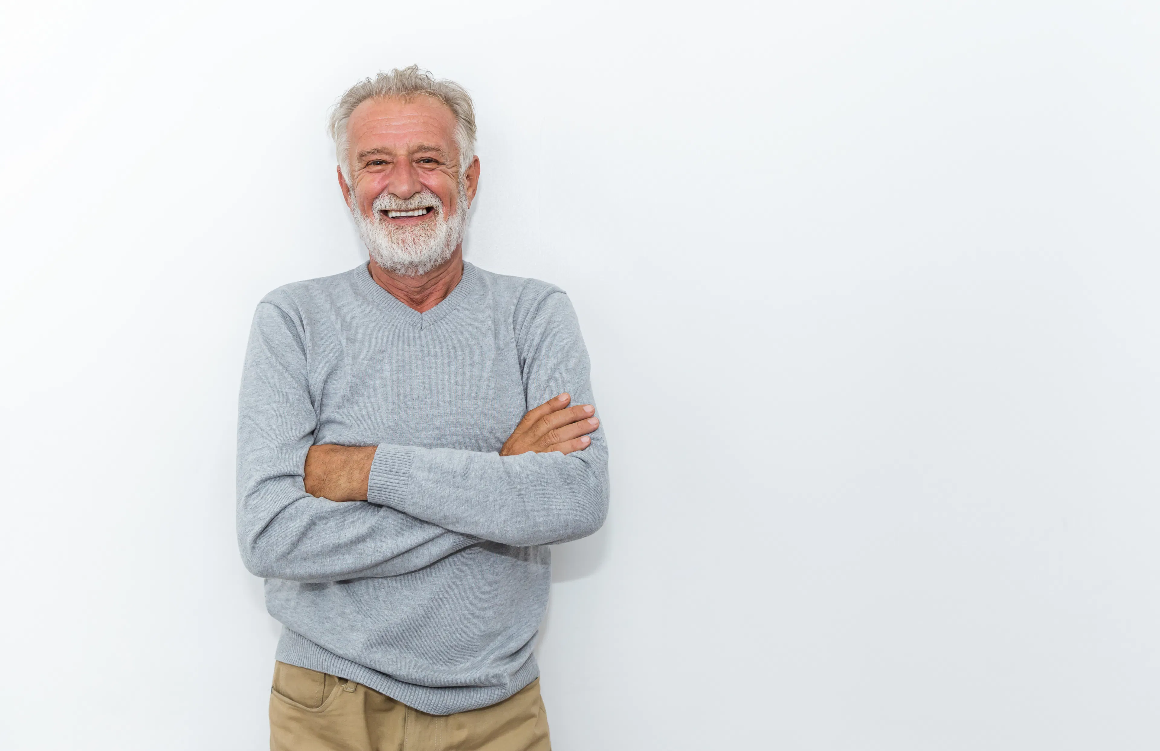 smiling mature man looking at camera with arms crossed