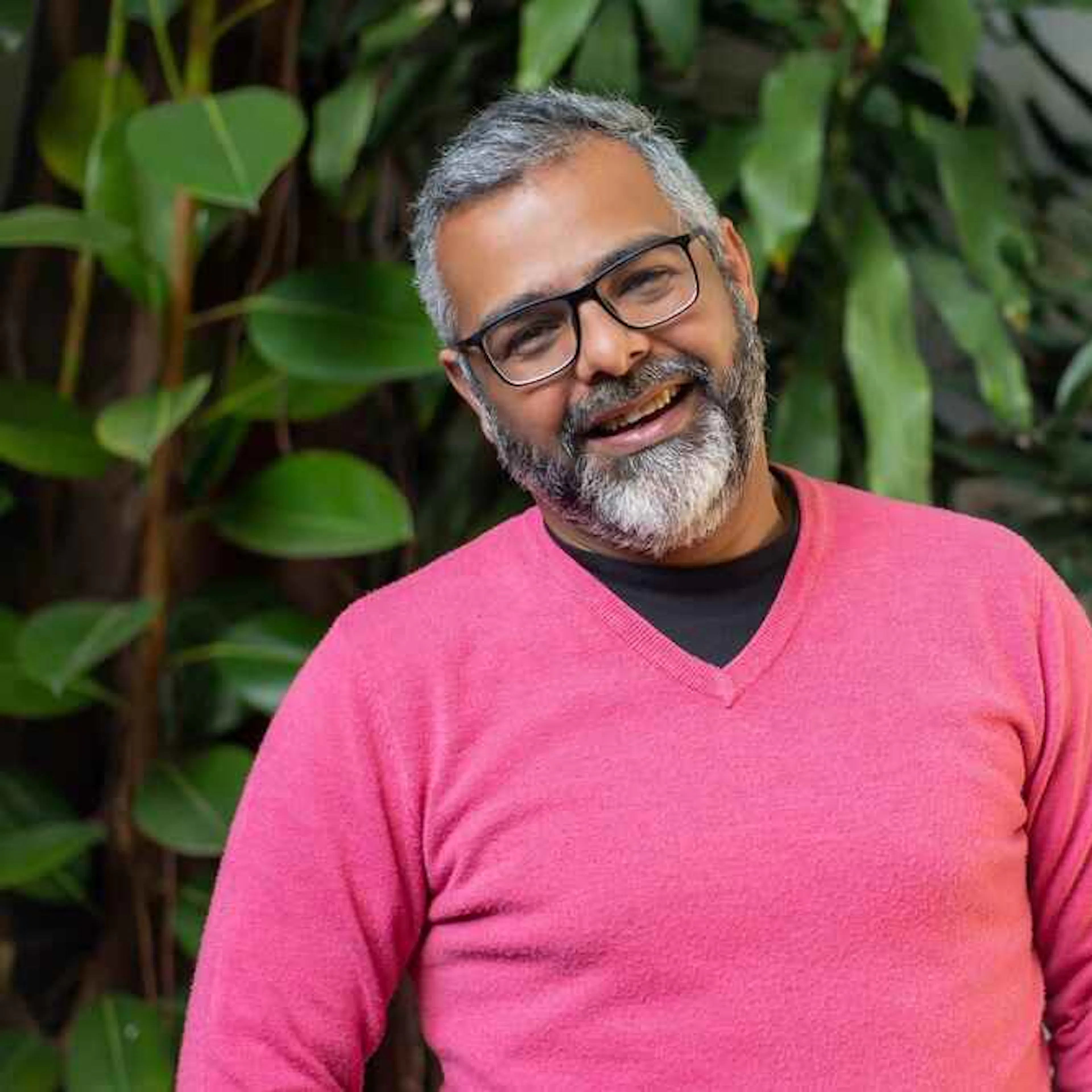 Older man with grey hair in pink jumper