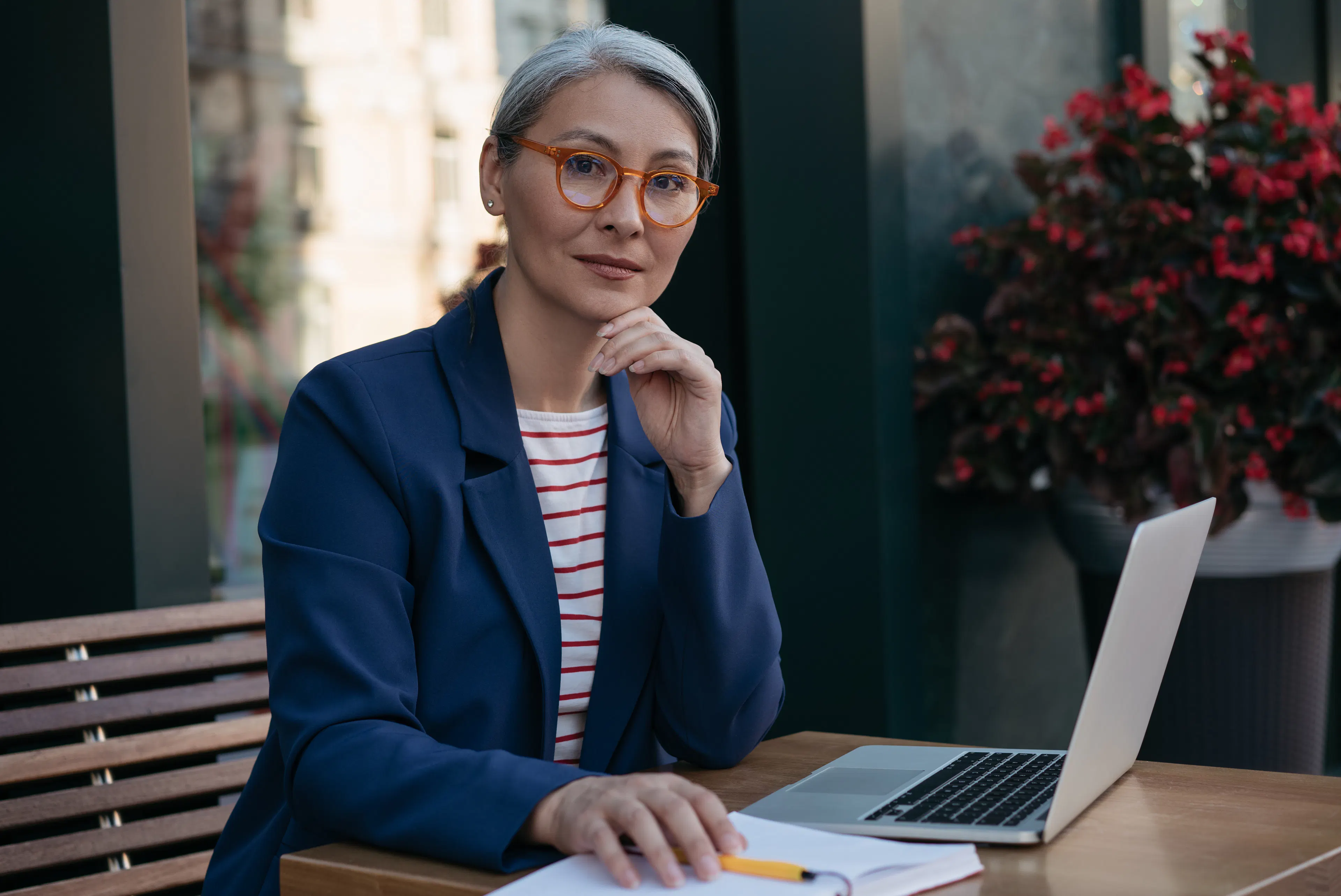 Smart older woman in blue blazer with laptop