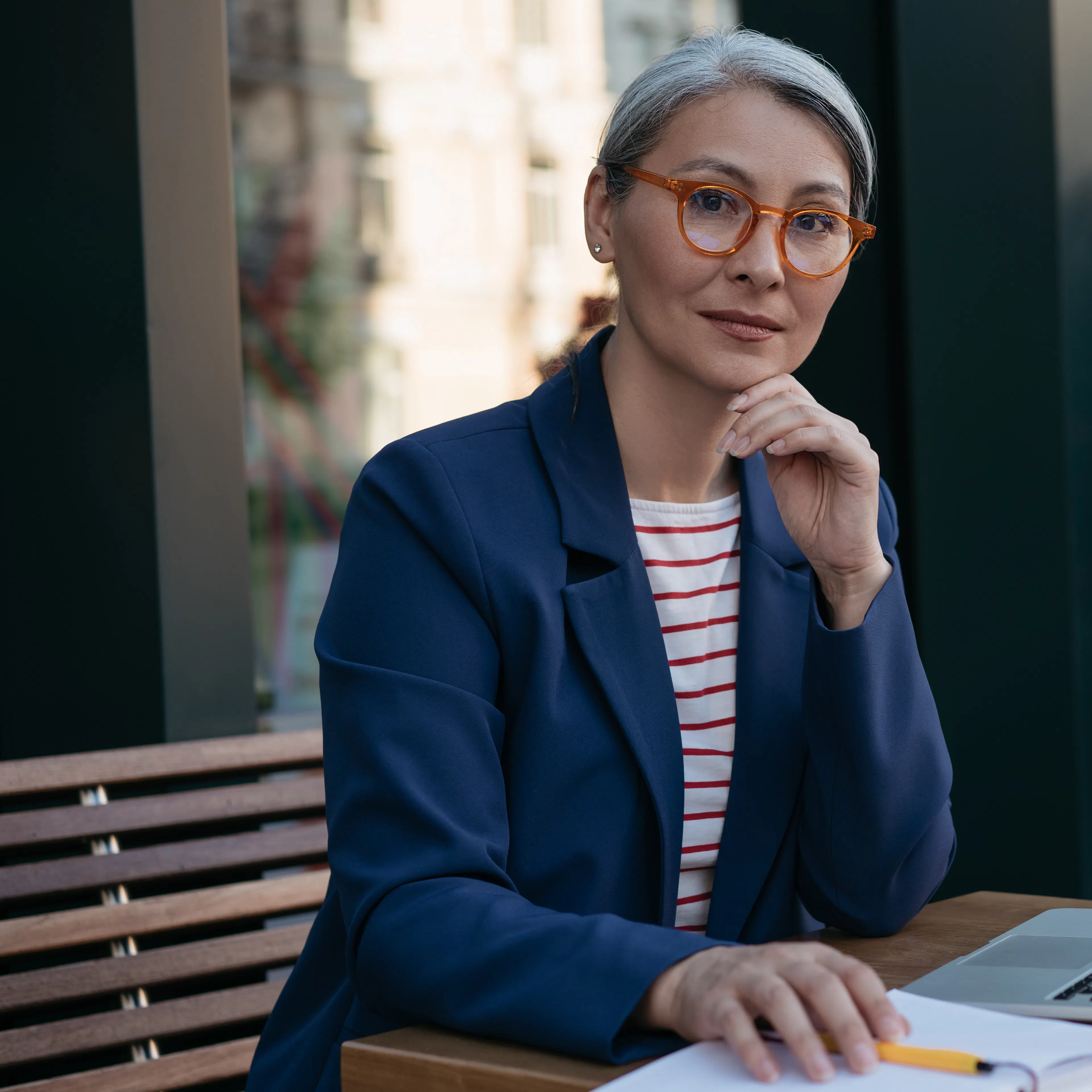 Smart older woman in blue blazer with laptop