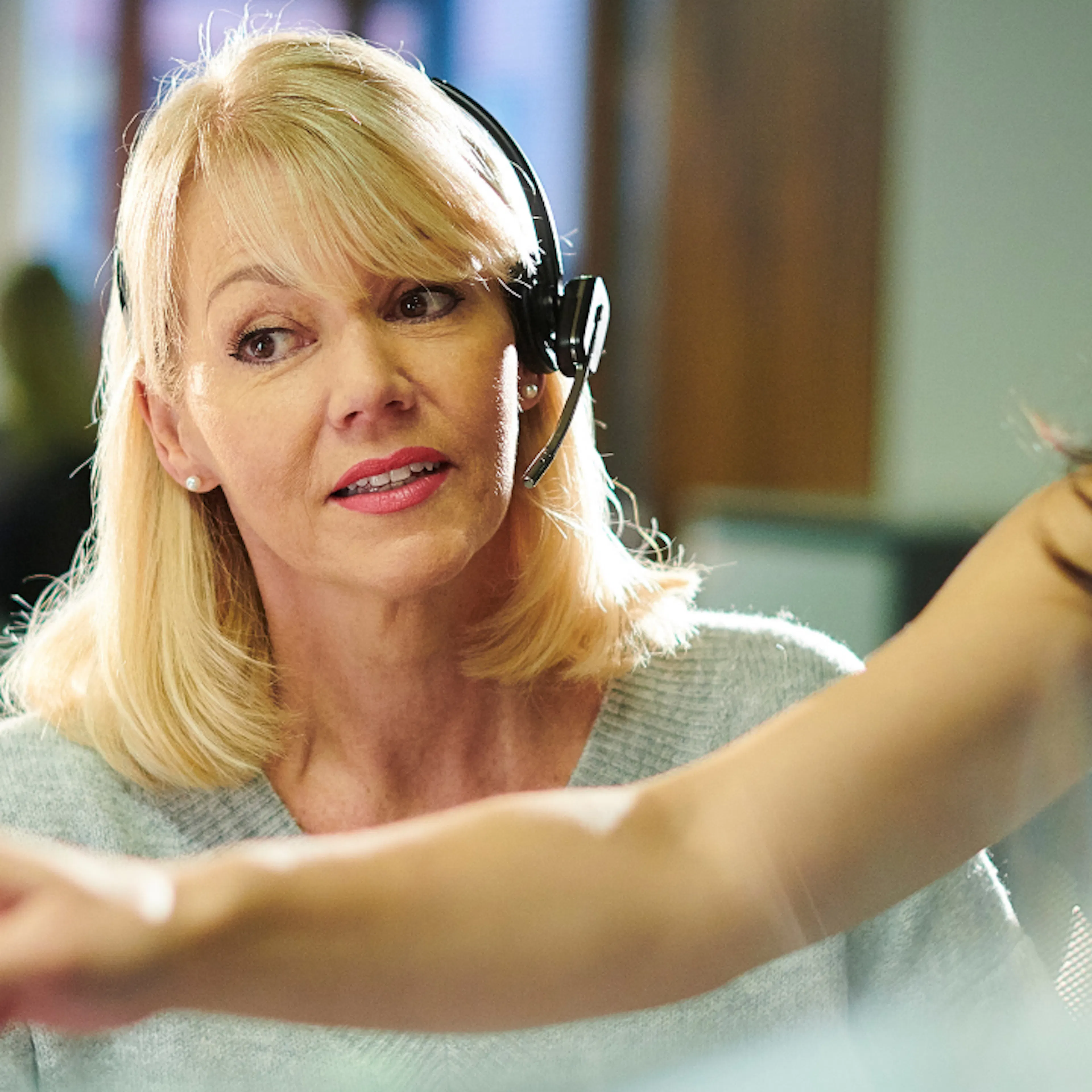 Woman wearing telephone headset being trained in a new system