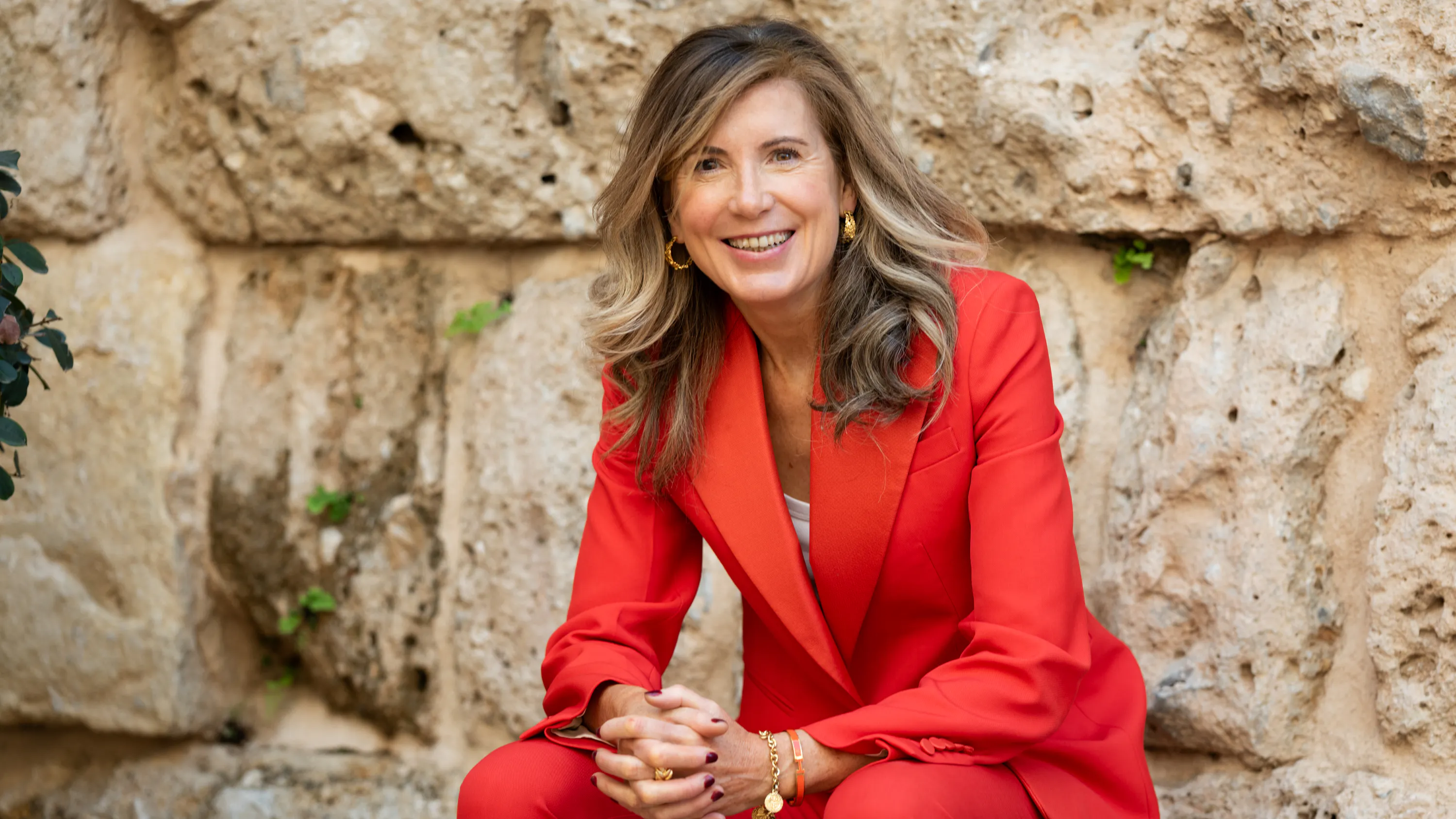 Karen Muldoon wearing red suit smiling at camera