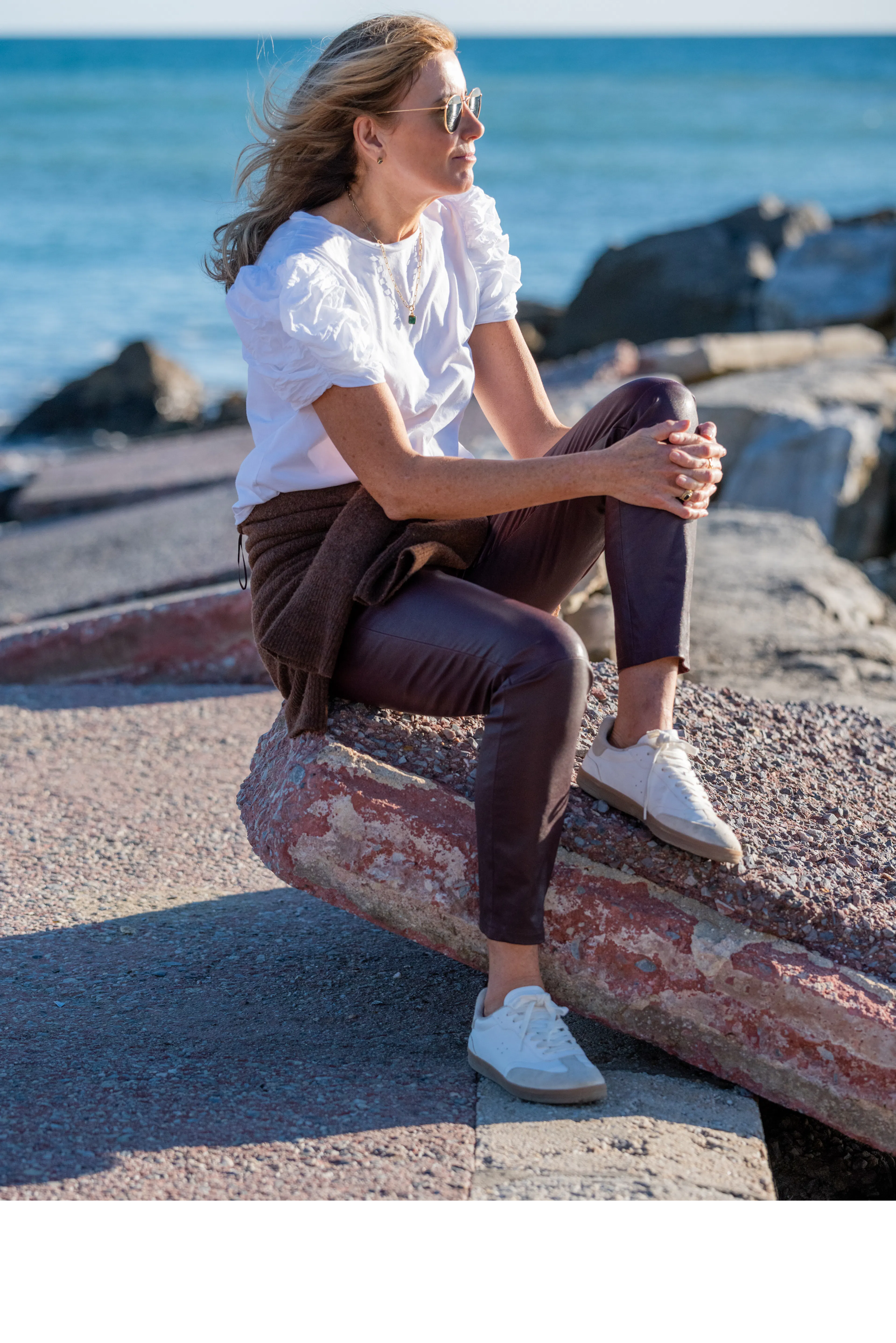 Karen Muldoon wearing leather pants by the ocean - looking away from camera
