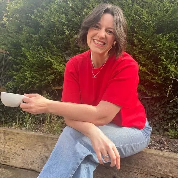 Ali Spooner seated with arms cross and a cup in hand