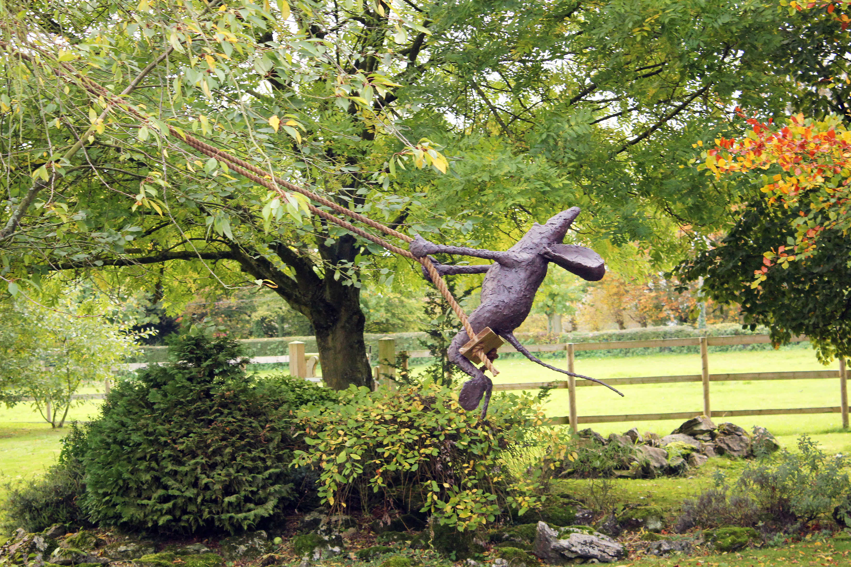 A sculpture of a mouse on a swing by Stephen Charlton.