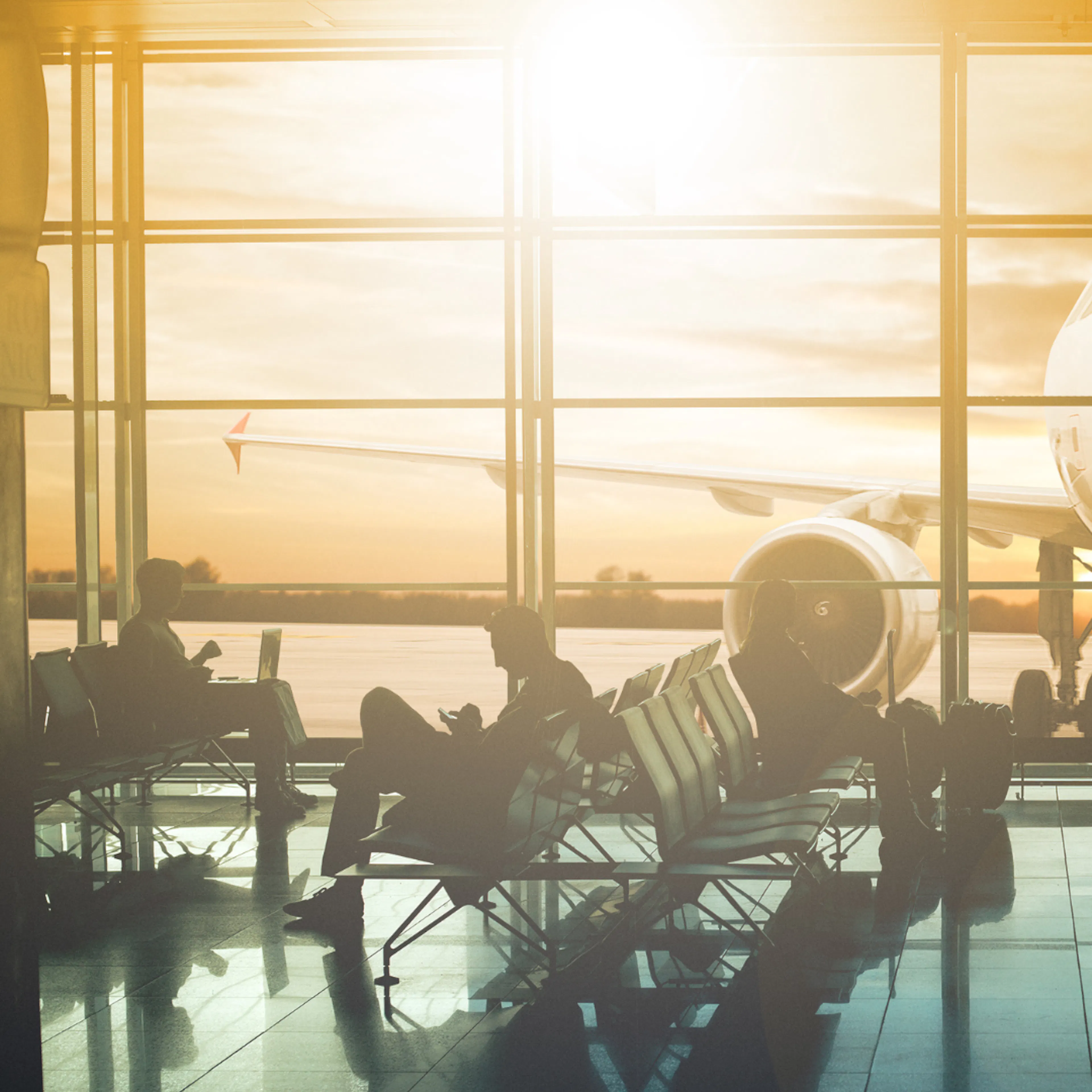 Departure lounge at the airport at sunset. Plane at the gate