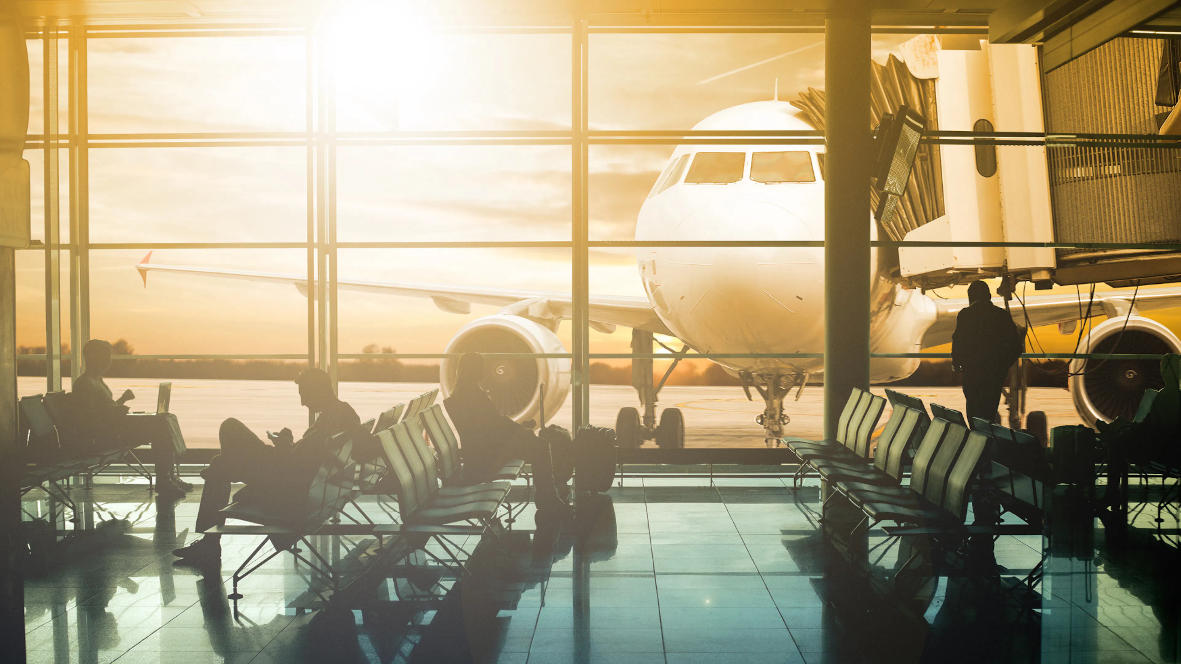 Departure lounge at the airport at sunset. Plane at the gate