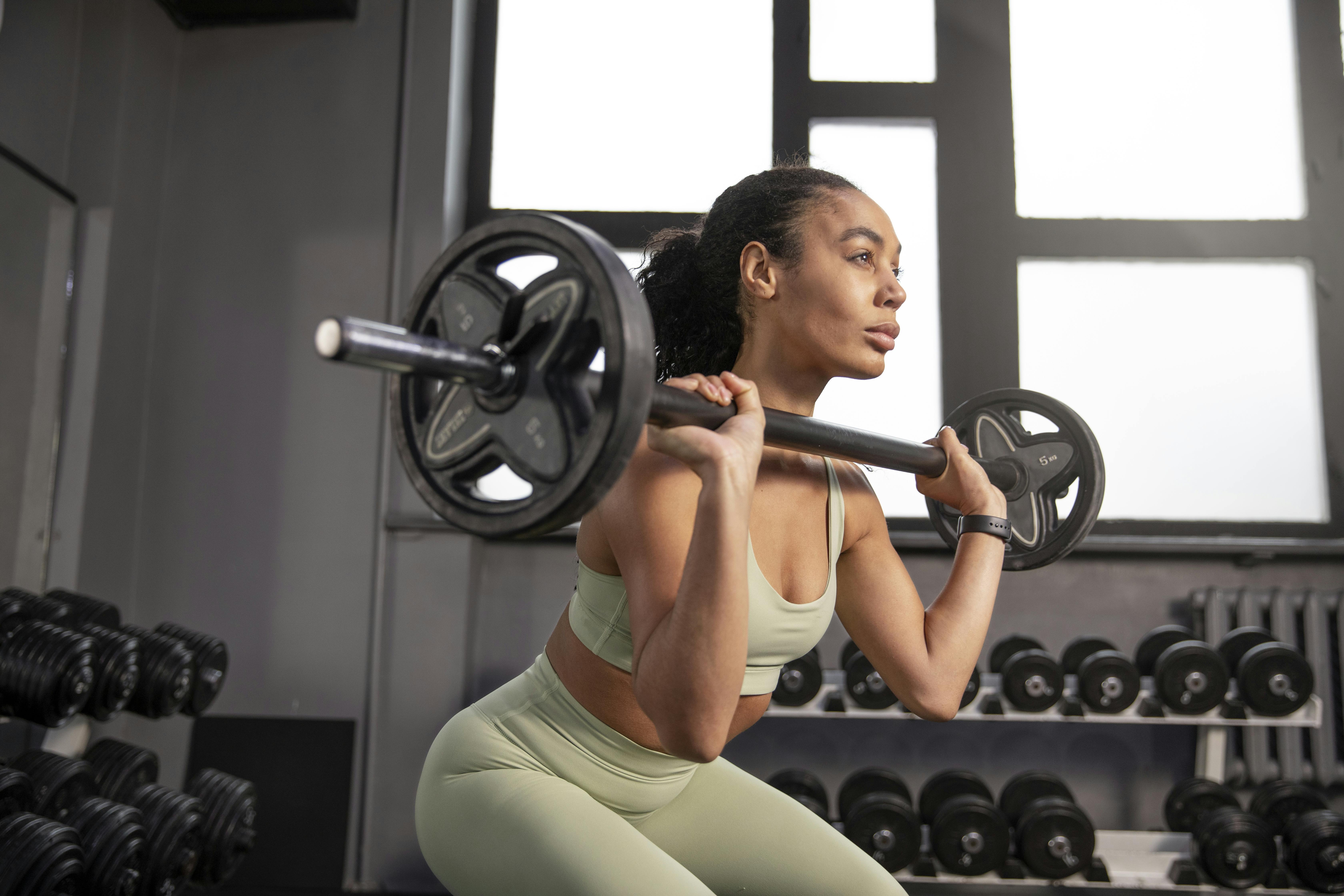 A woman is trying to get into a front squat.