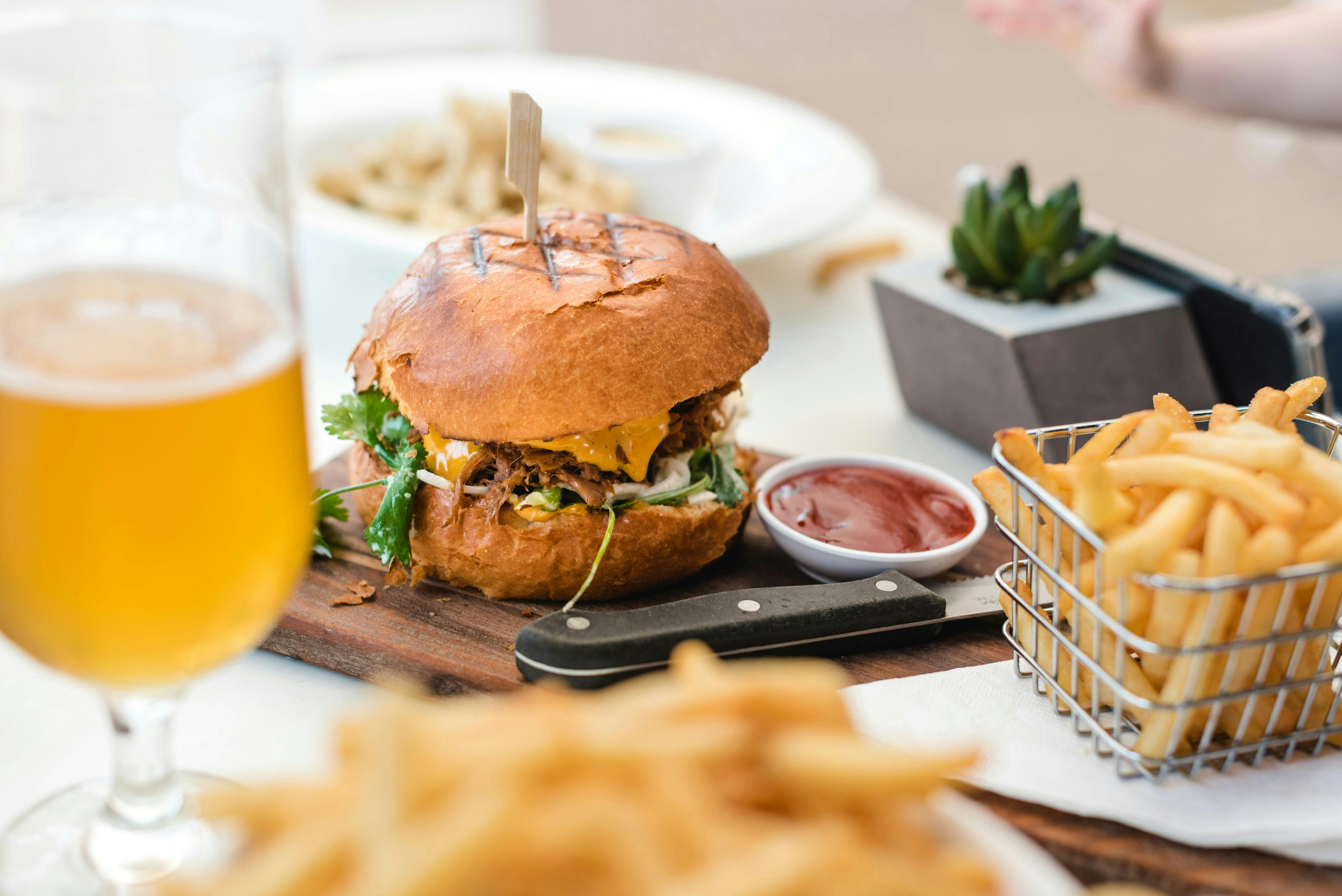 Photo of a burger, fries, and Belgian beer.