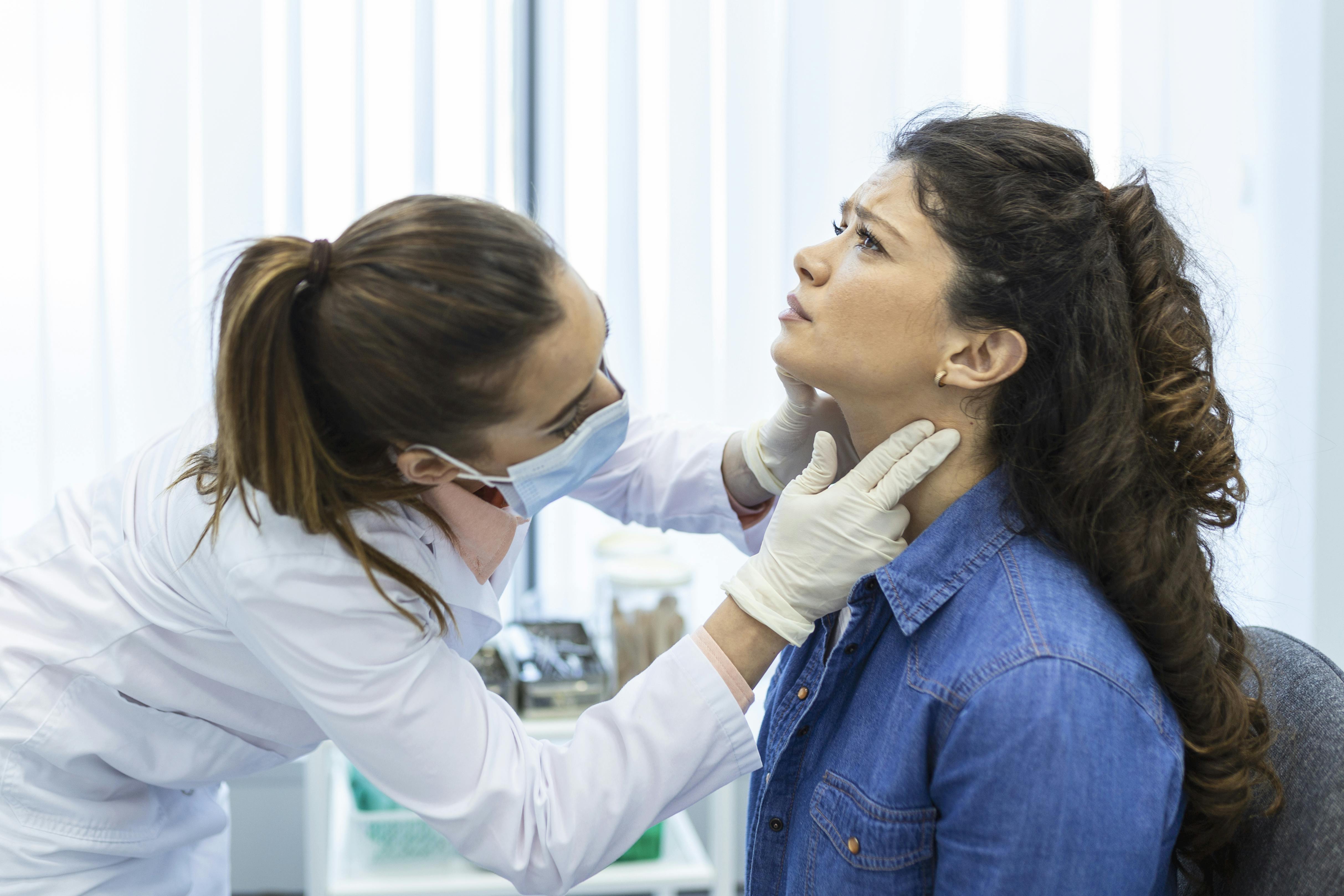An endocrinologist is examining someone's thyroid.
