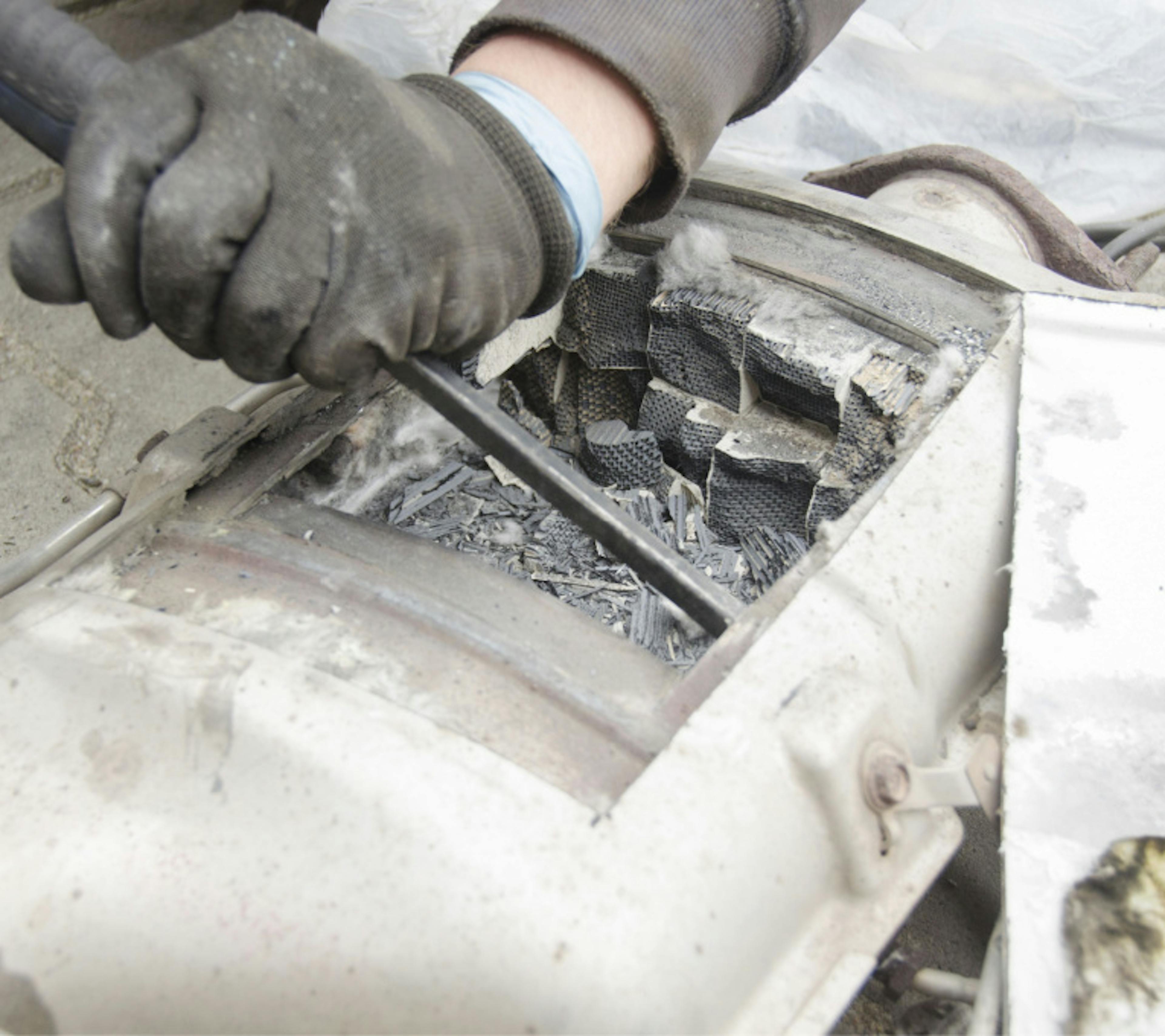 Technician removing a DPF core in attempt to repair the DPF