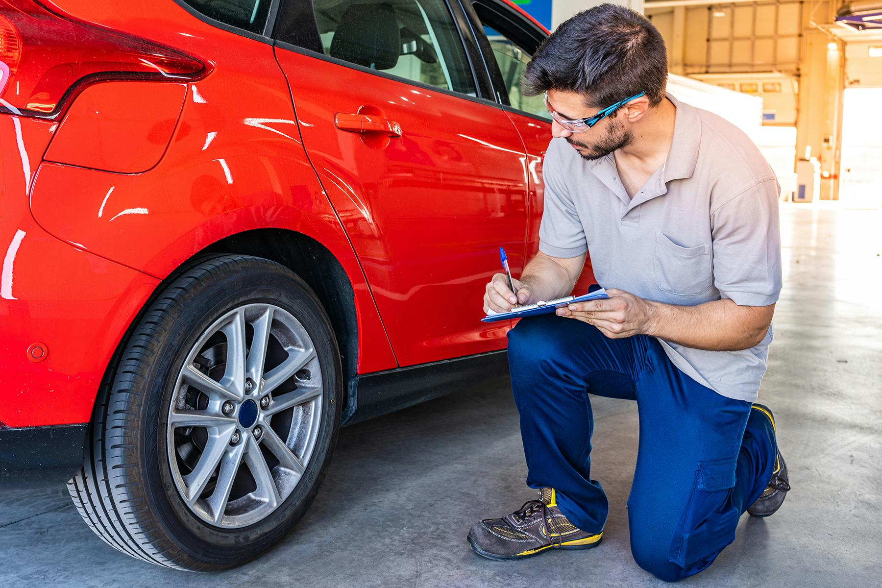 A mechanic inspecting a car tyre