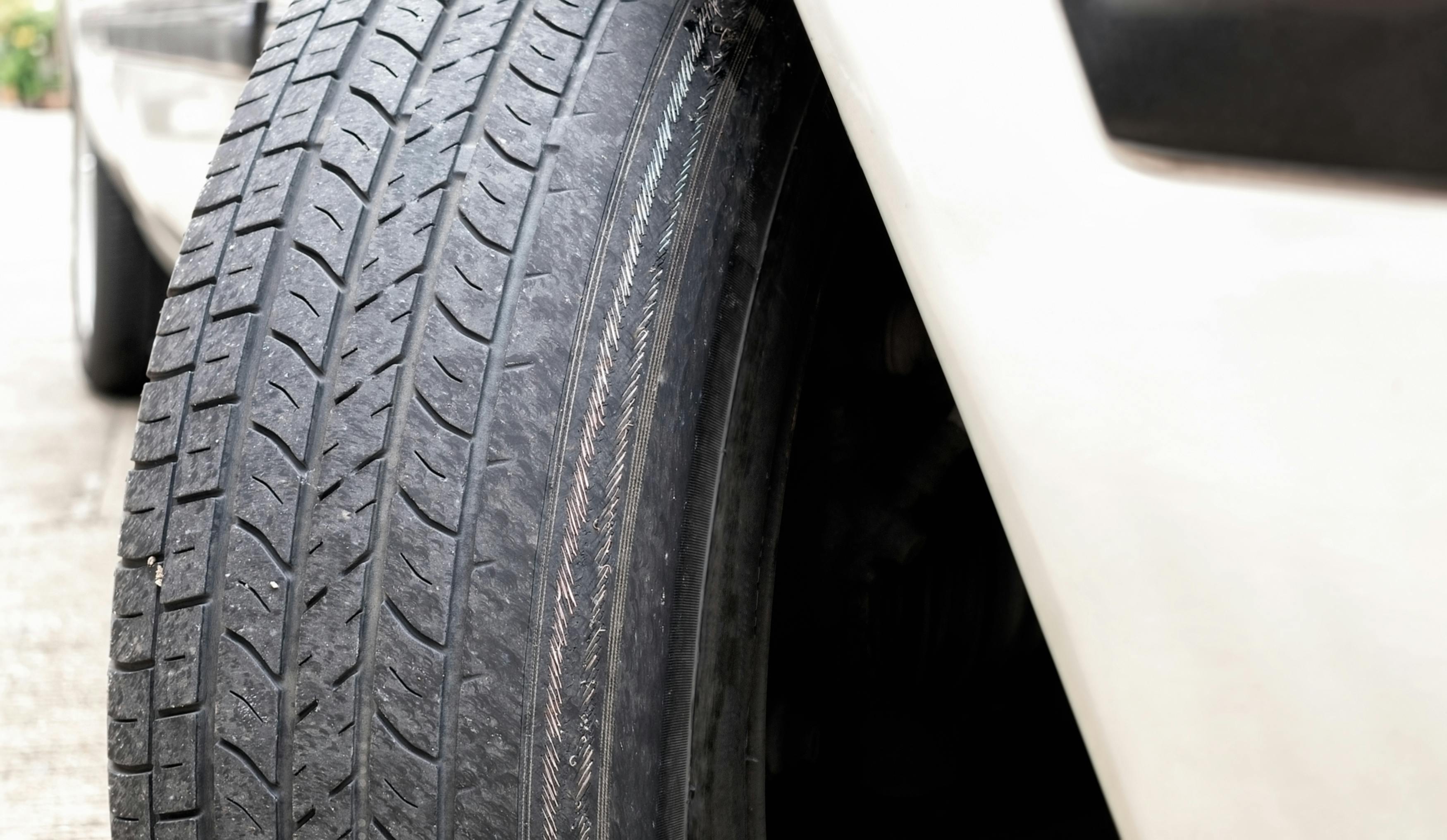 A worn car tyre caused by excessive wheel alignment toe-out