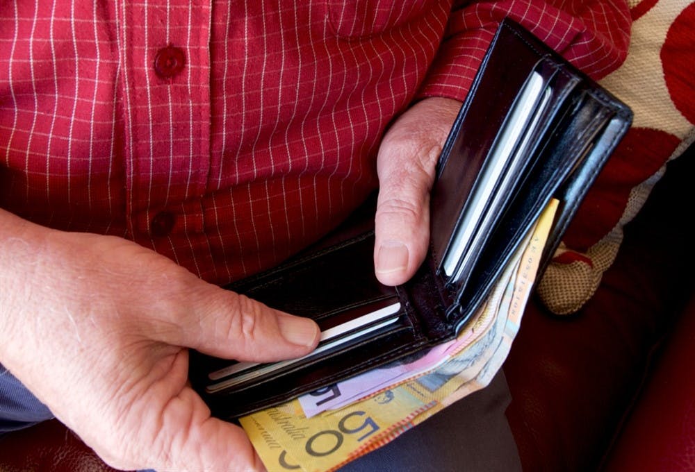 A man taking a bank note out of his wallet