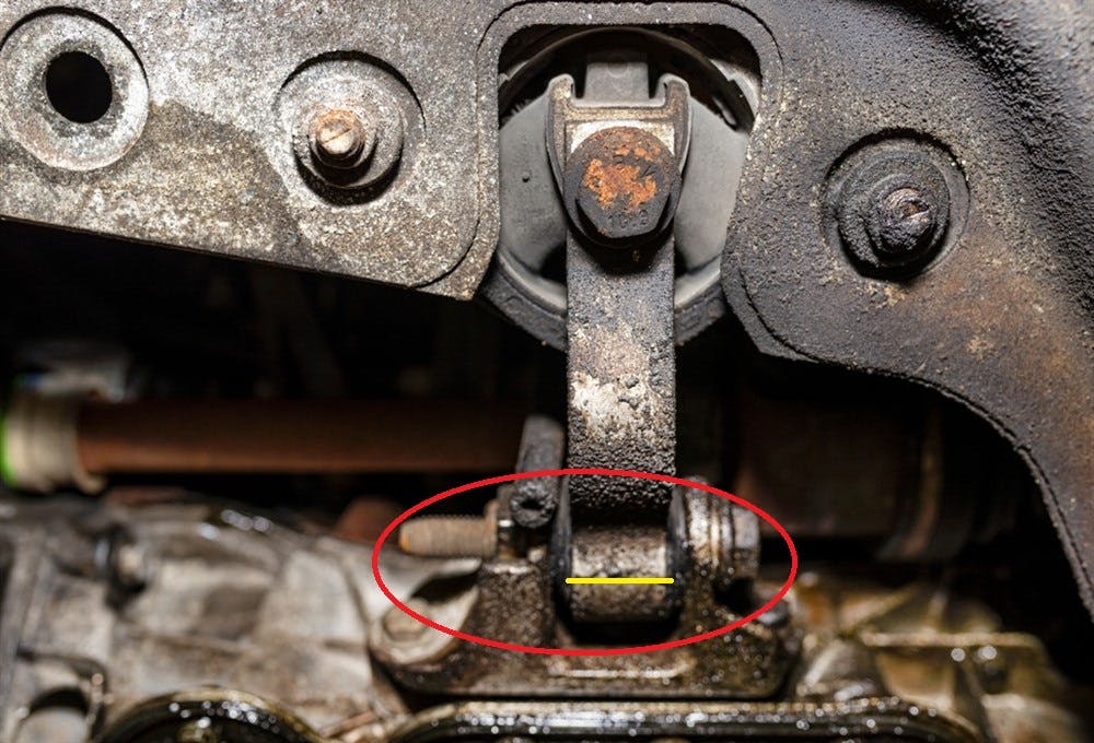 Image shows the damaging effect of oil leaks on engine mounts. 