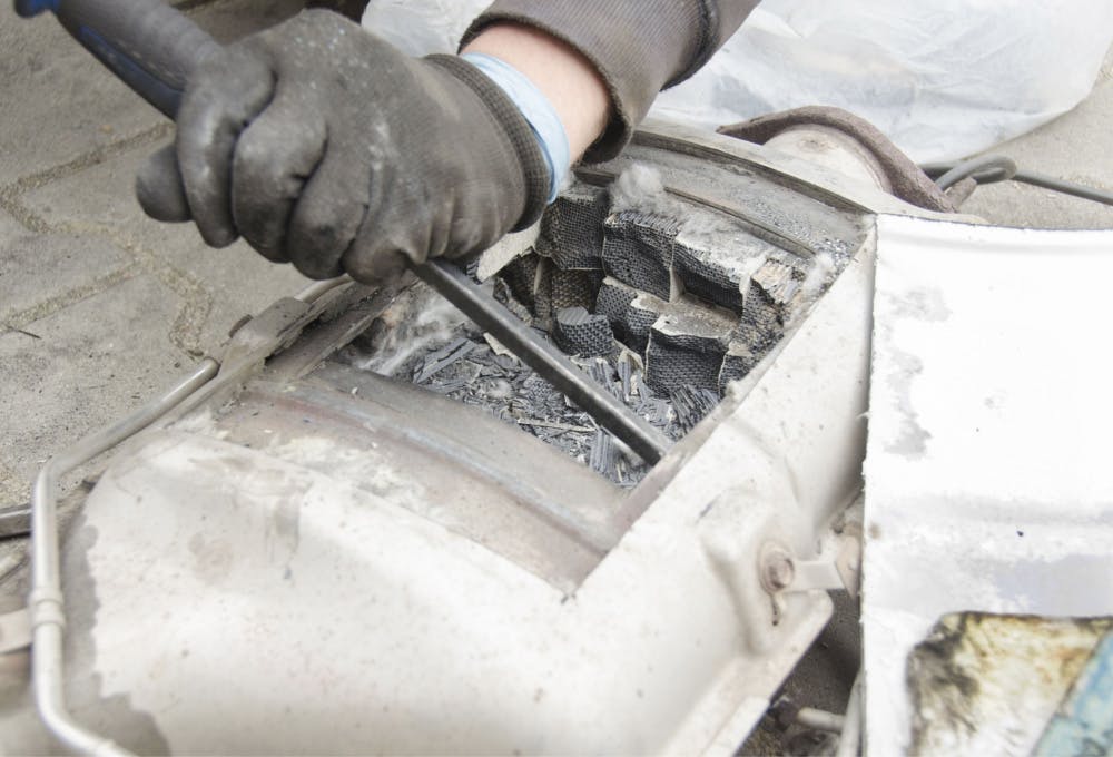 Technician removing a DPF core in attempt to repair the DPF