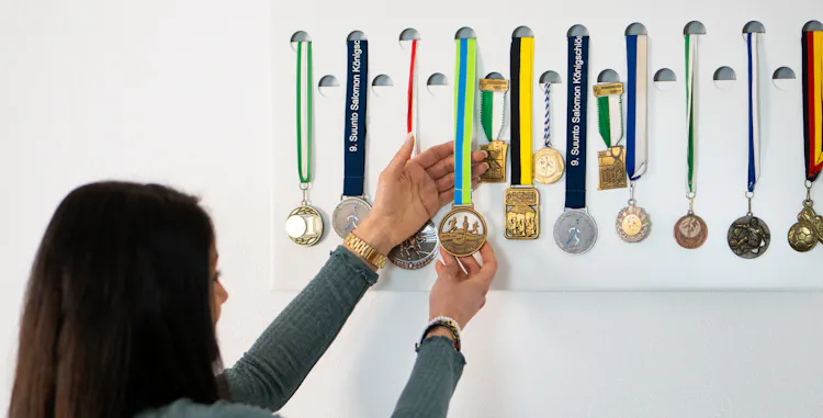 Die Sportlerin betrachtet stolz ihre Medaillen, welche sie an der STAGE 38 angebracht hat