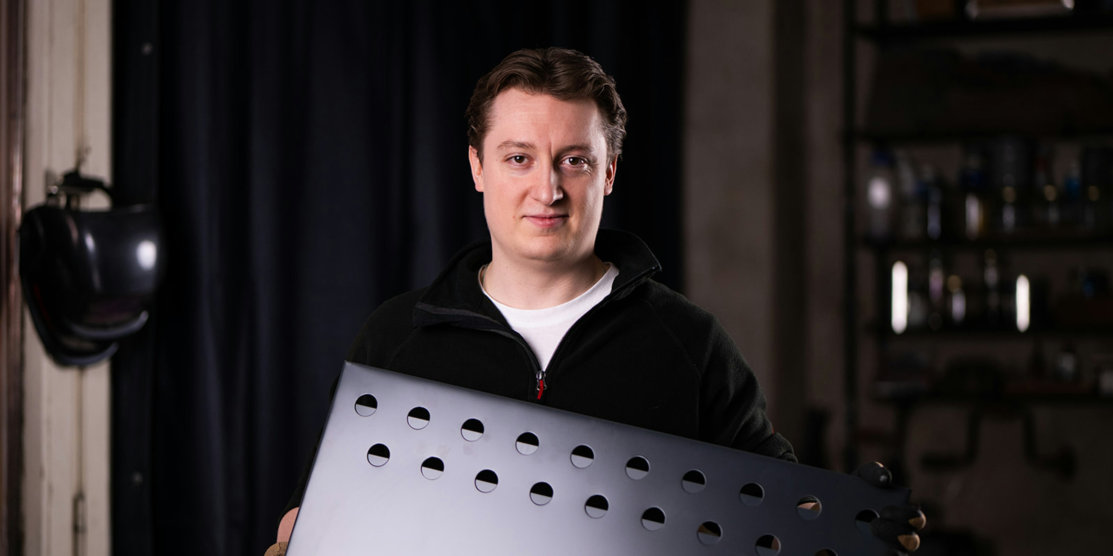 Mann hält modernen Medaillenhalter zum Aufhängen von Medaillen in Werkstatt