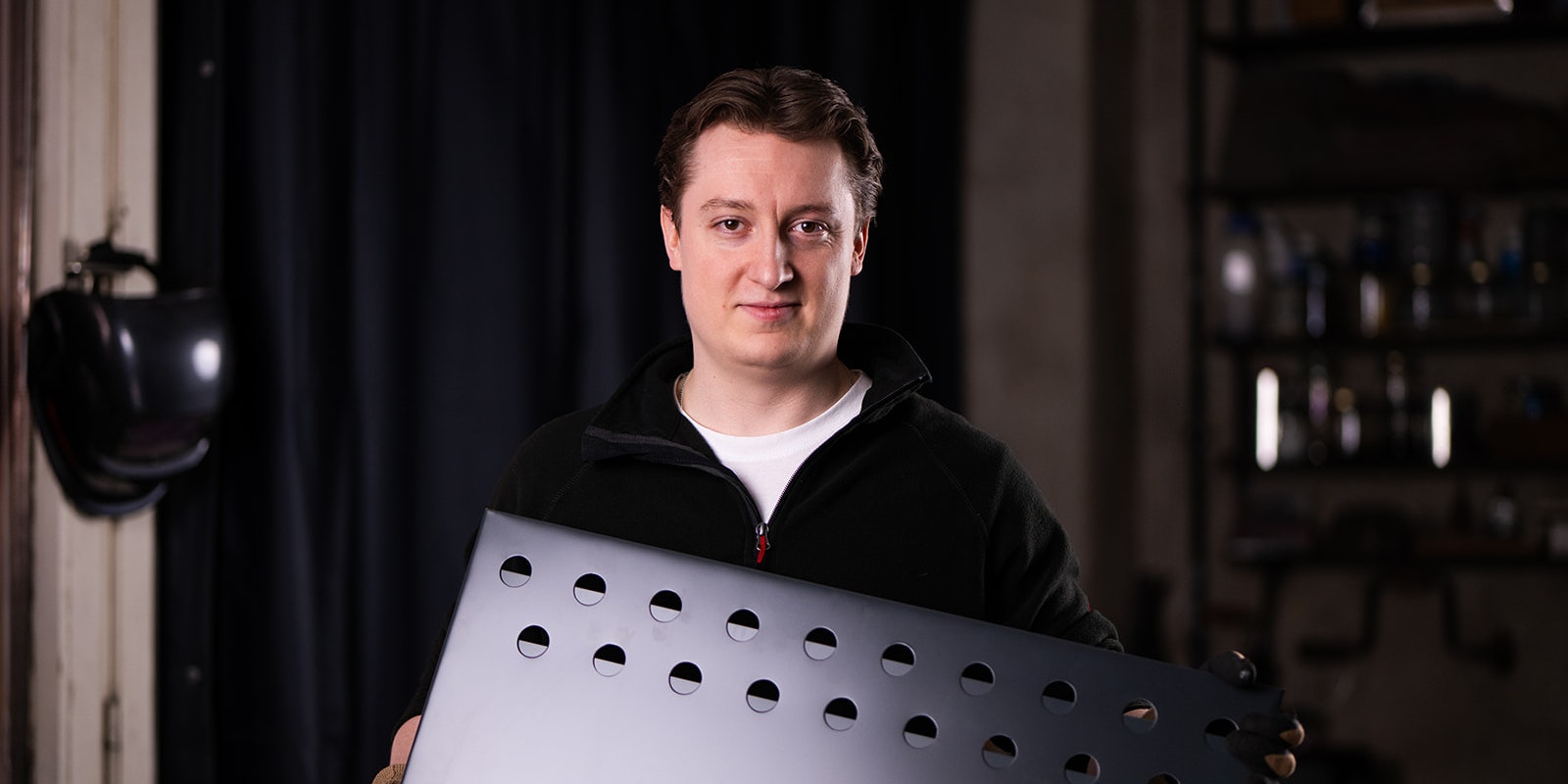 Mann hält modernen Medaillenhalter zum Aufhängen von Medaillen in Werkstatt