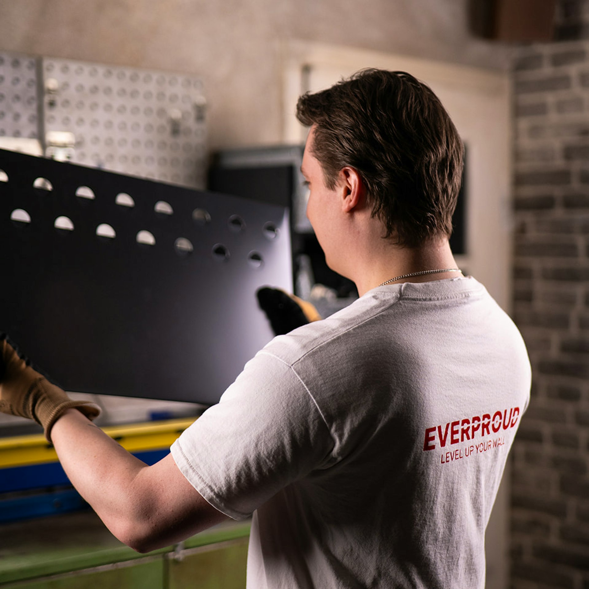 Mann montiert Medaillenhalter aus Aluminium zum Aufhängen von Medaillen an der Wand