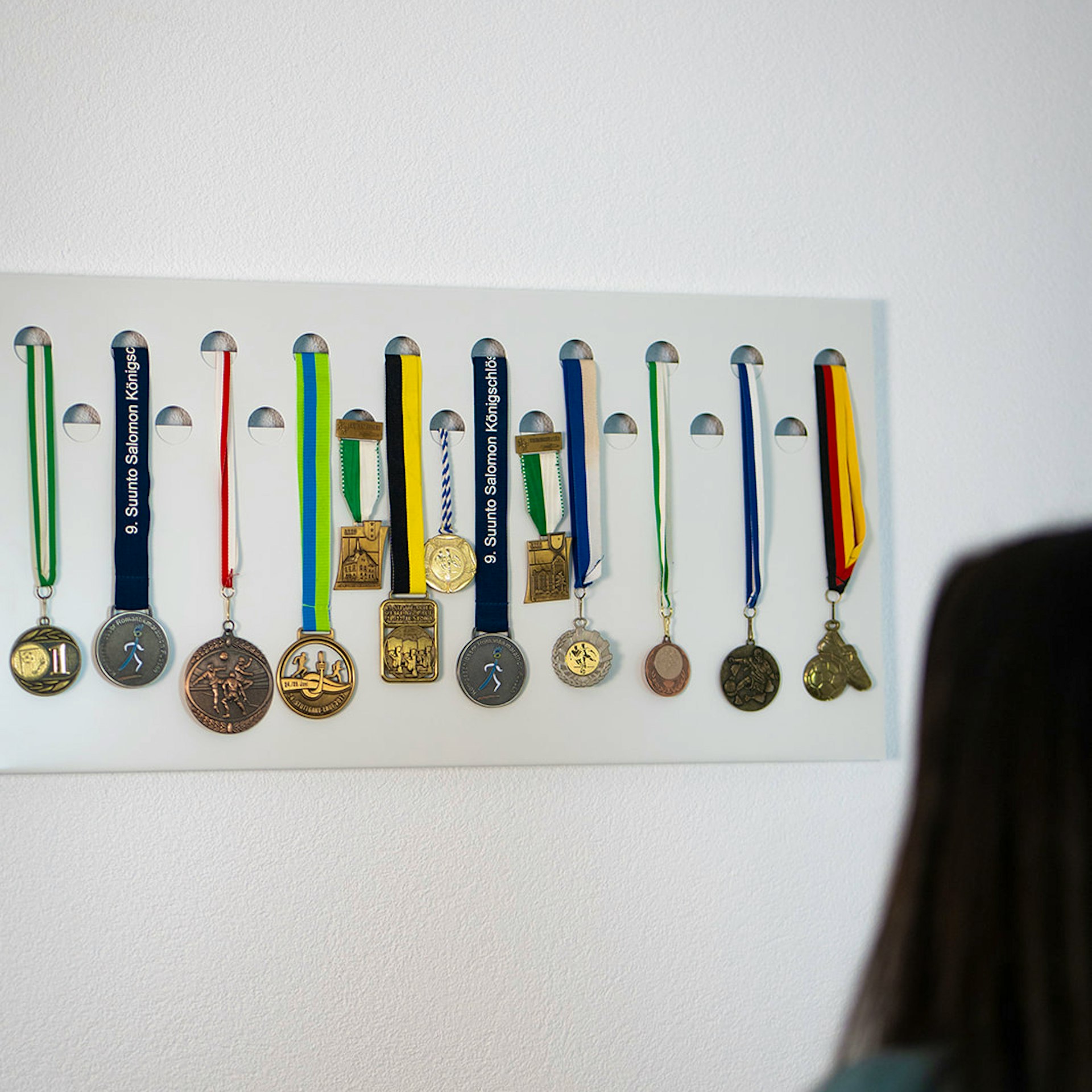 Medaillenhalter Aluminium mit aufgehängten Medaillen an der Wand