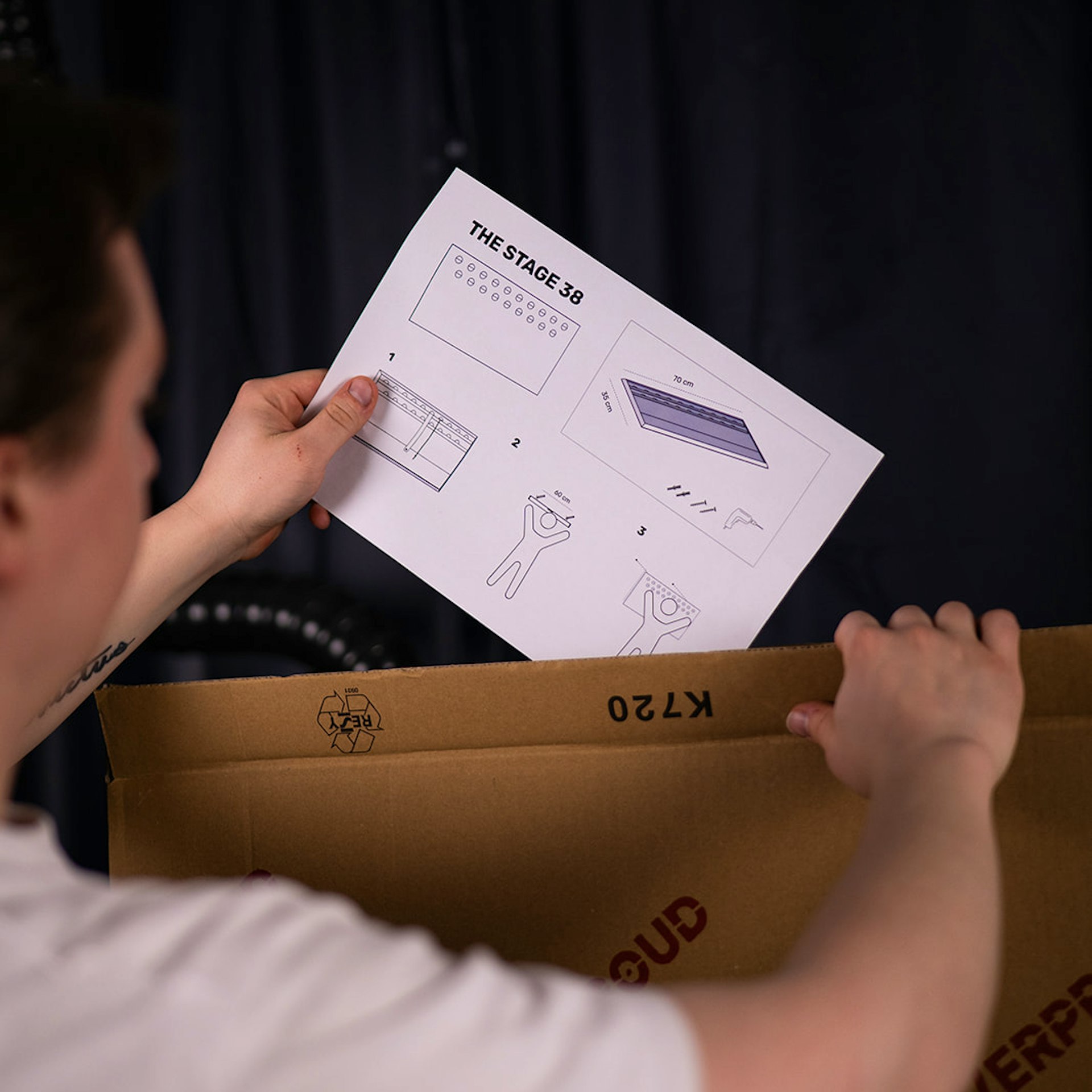 Montageanleitung für Medaillenhalter aus Aluminium wird in Verpackung gelegt