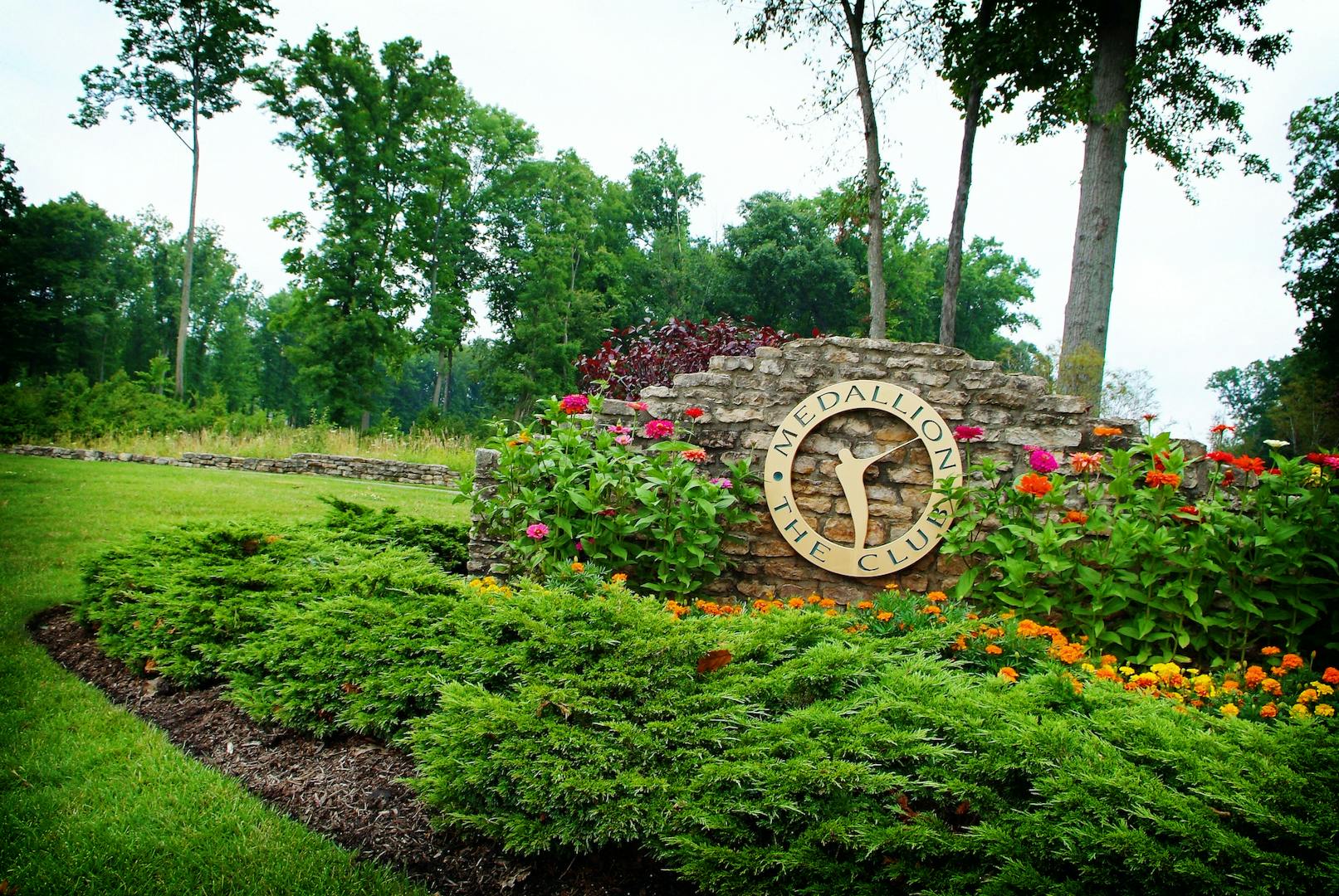 Image of The Medallion Club entry sign with flowers in bloom.