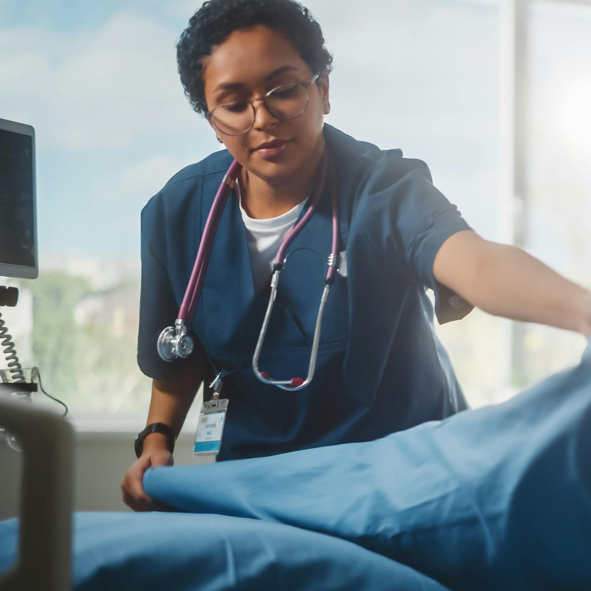 health professional cleaning room and making bed