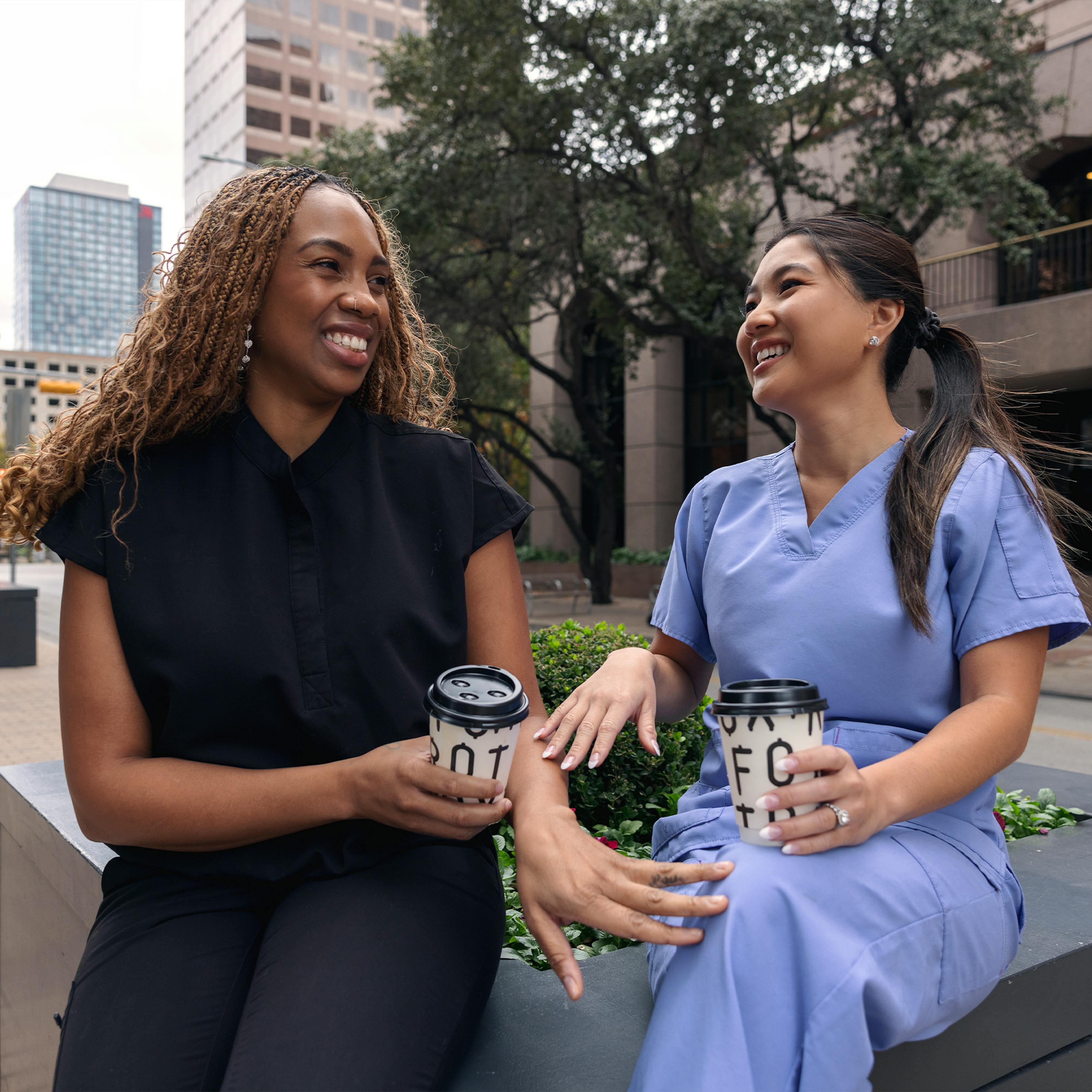 Two nurses enjoying coffee together in downtown area