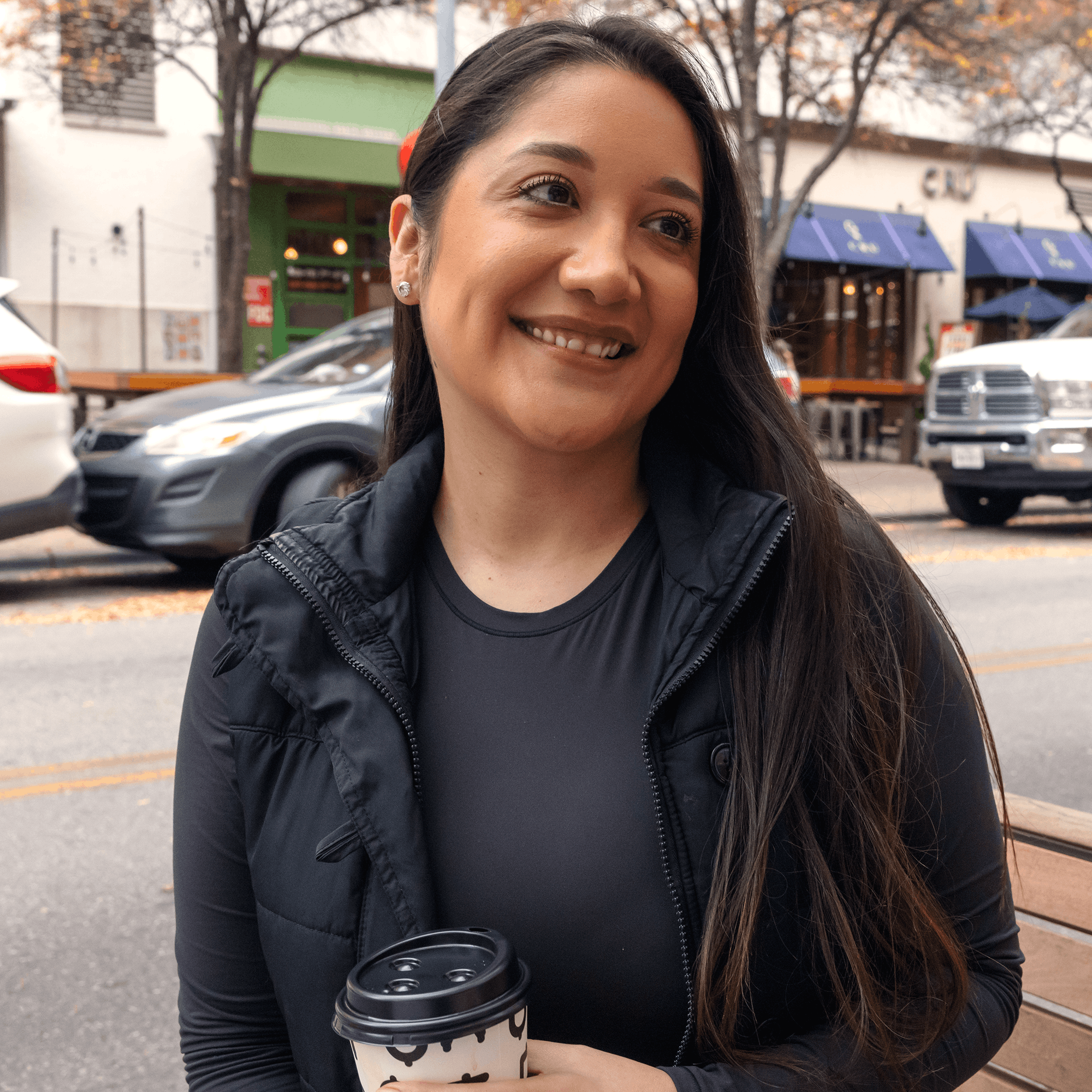 Medely employee on bench in downtown area smiling