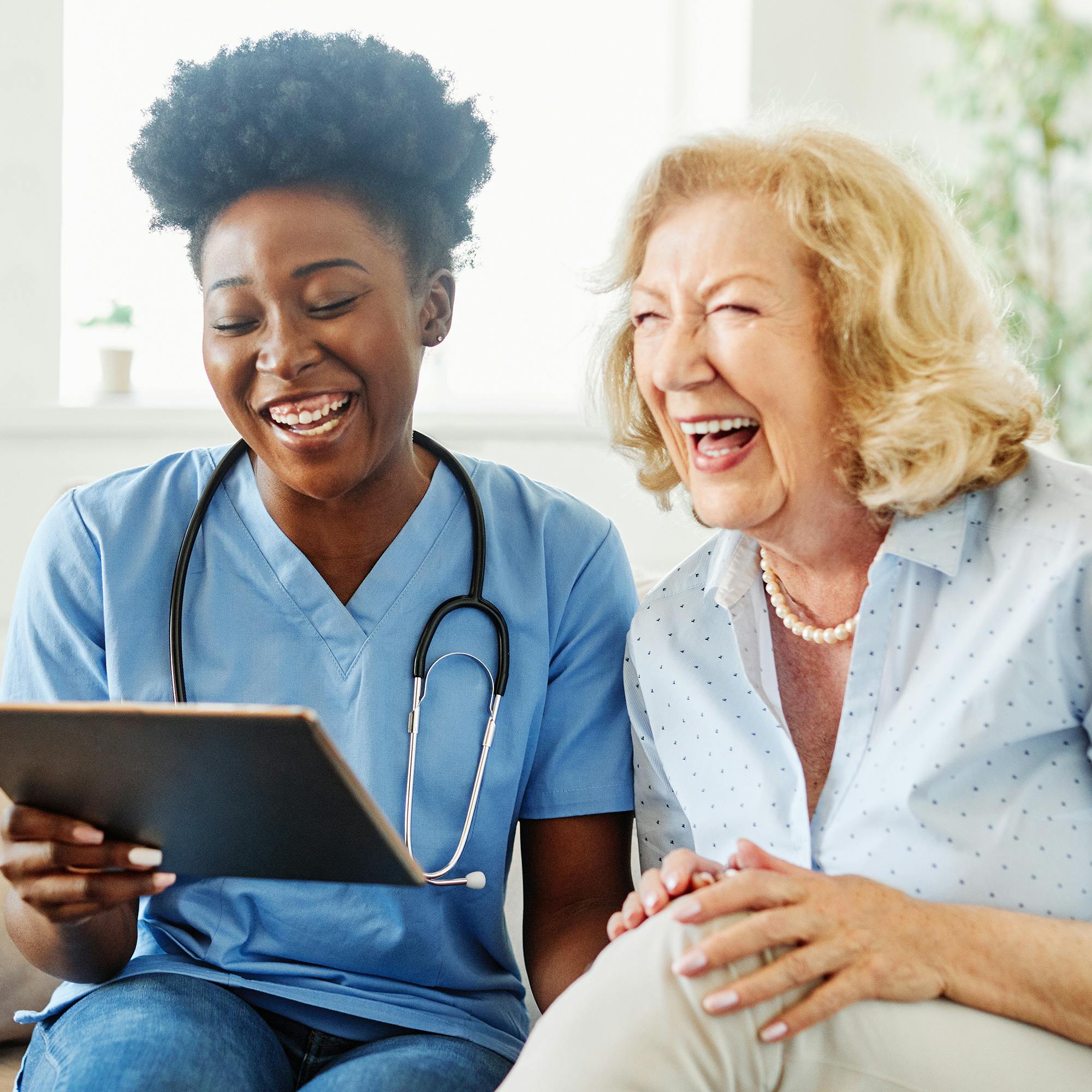 Elderly patient and nurse smiling together